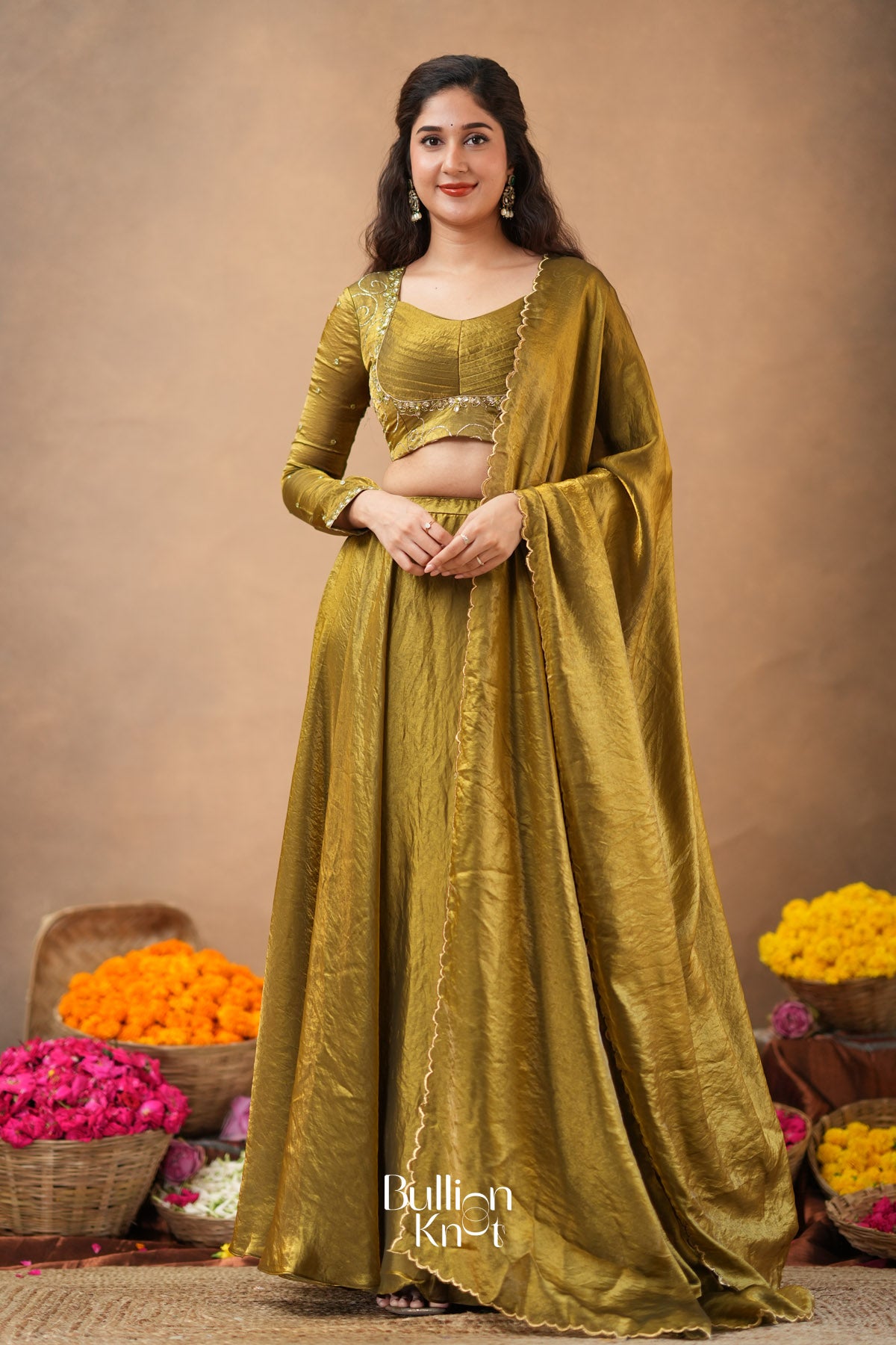 Woman in a green traditional outfit with flowers in the background