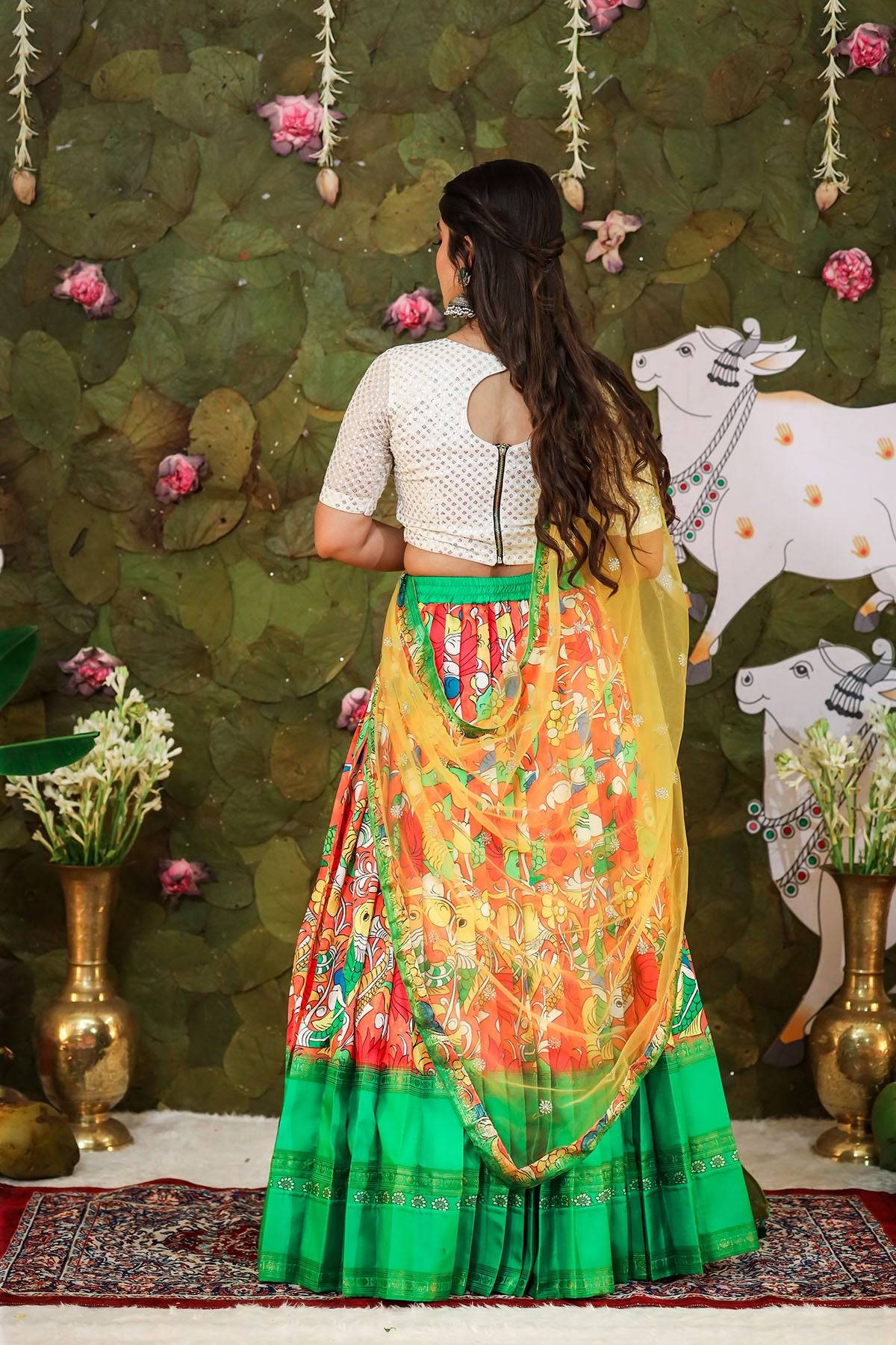 a woman in white red and parrot green banarasi silk half saree
