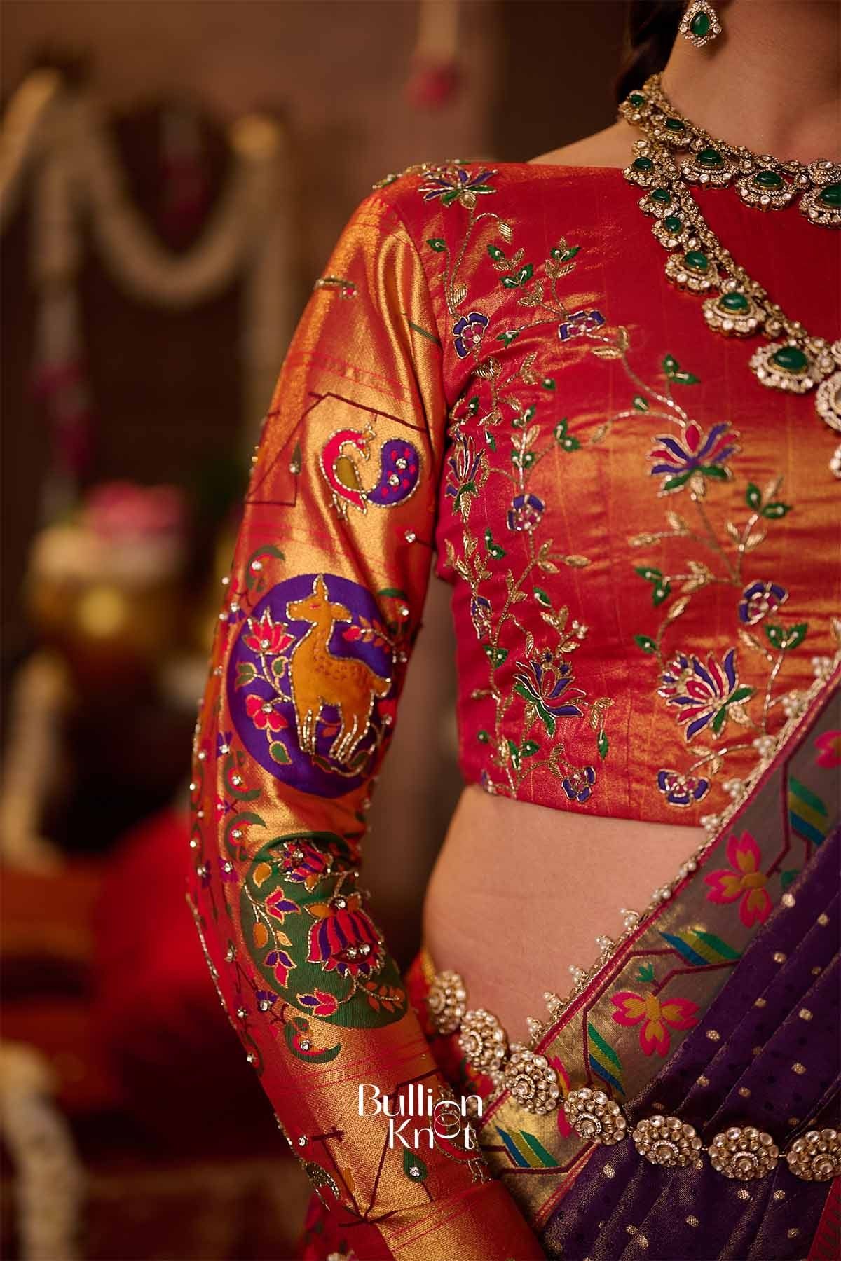 Detailed view of the golden waistband with floral embellishments, complementing the colorful embroidered lehenga for wedding celebrations