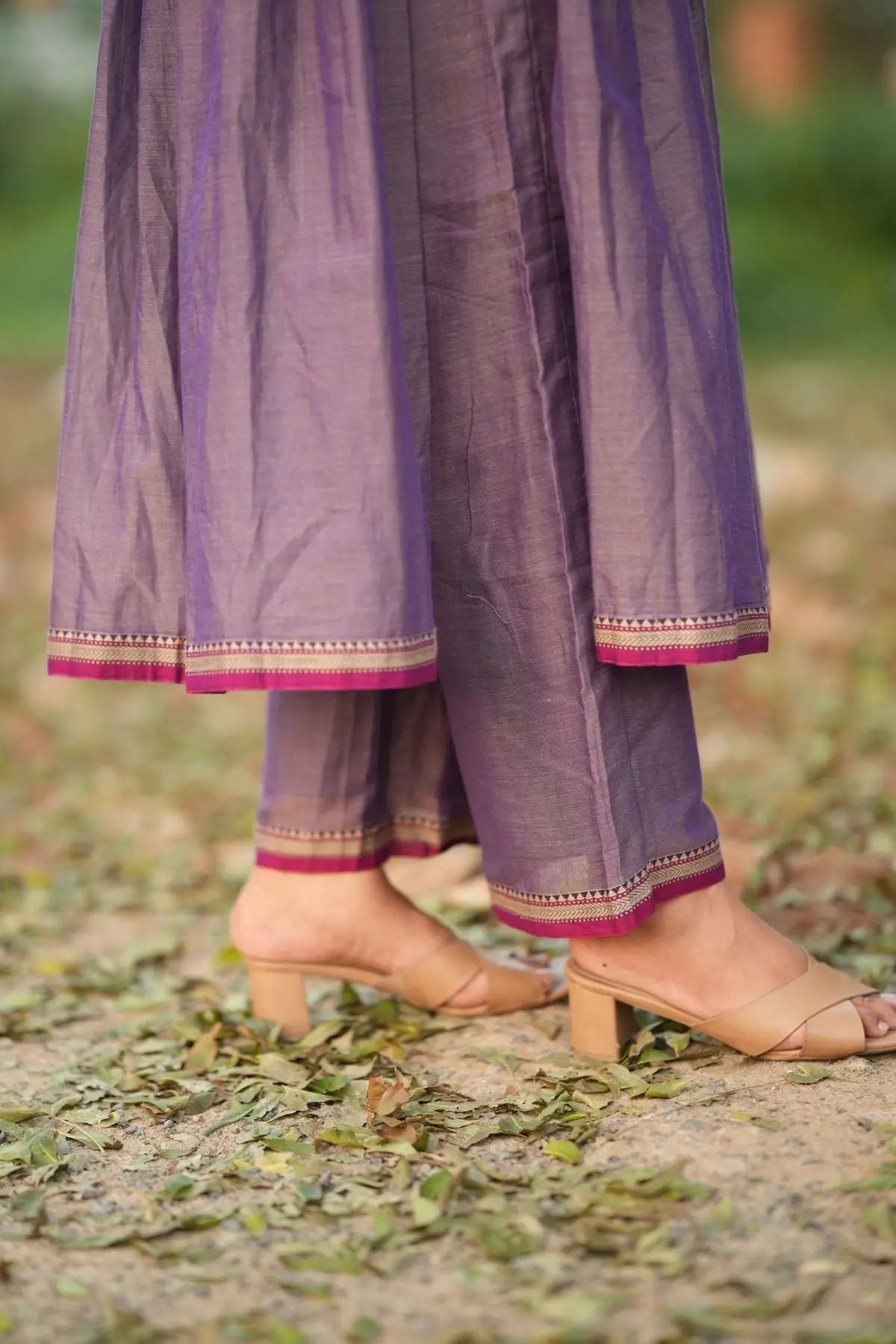 Bottom hem of Lipika Kurta Set pants in greyish lavender with pink and gold trim, paired with nude heels for a complete ethnic look.