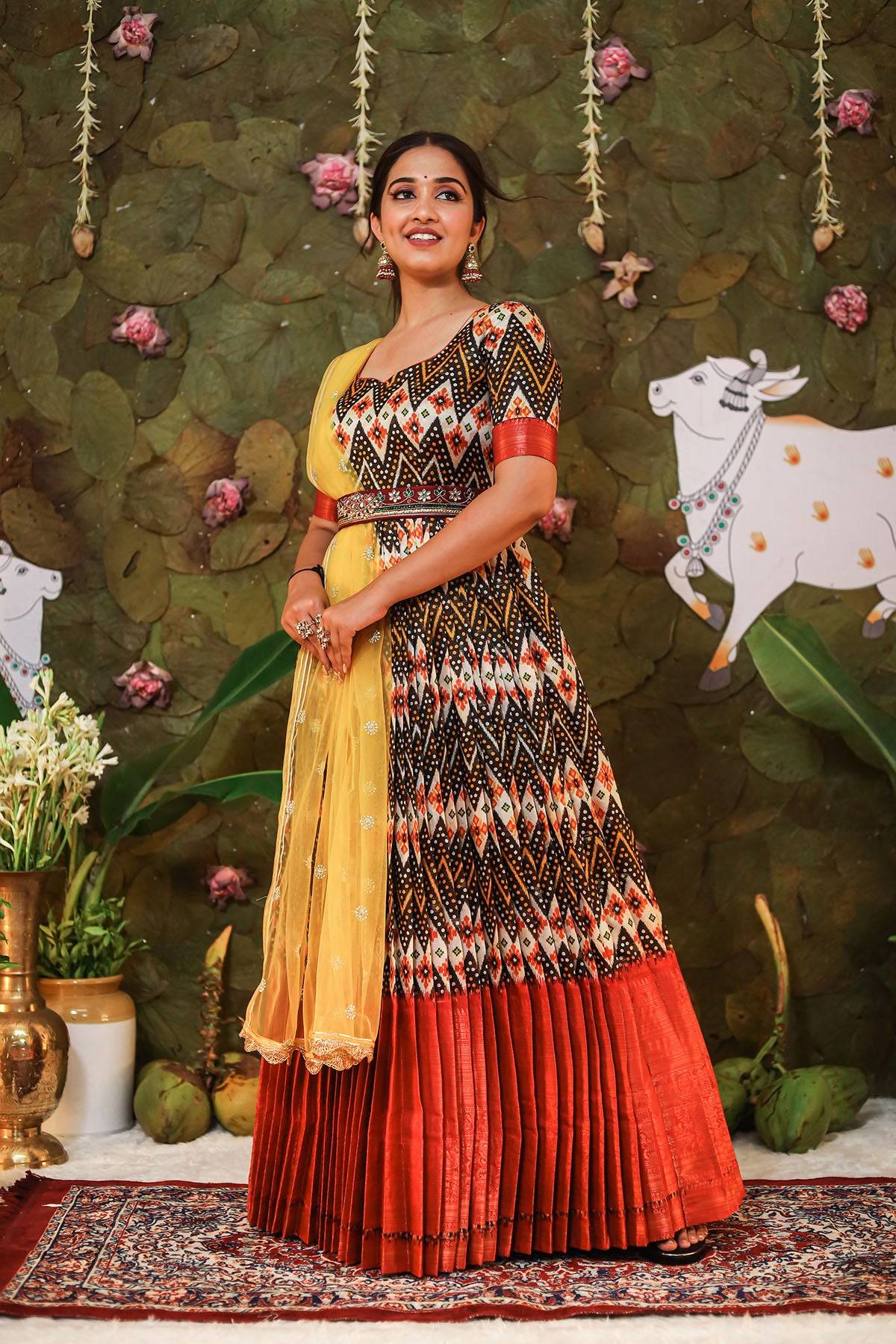 a woman in black, maroon and yellow pattu dress