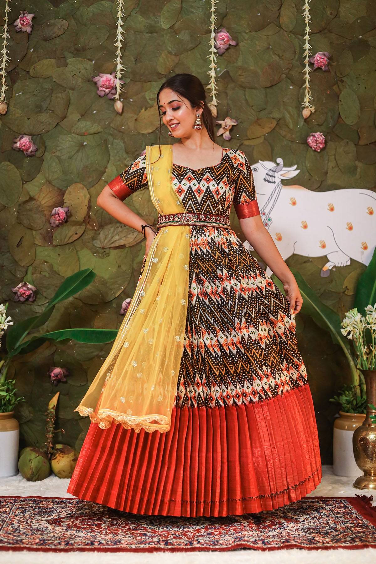 a woman in black, maroon and yellow half saree