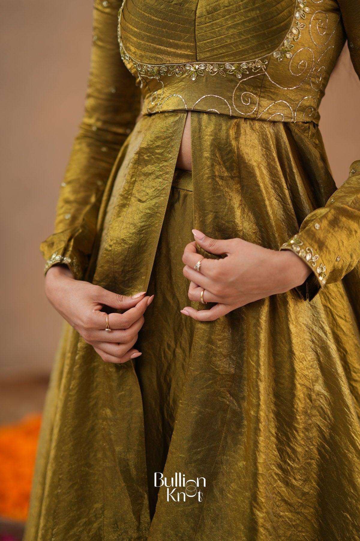 Gold traditional outfit with intricate designs, featuring the brand 'Bullion Knot'.