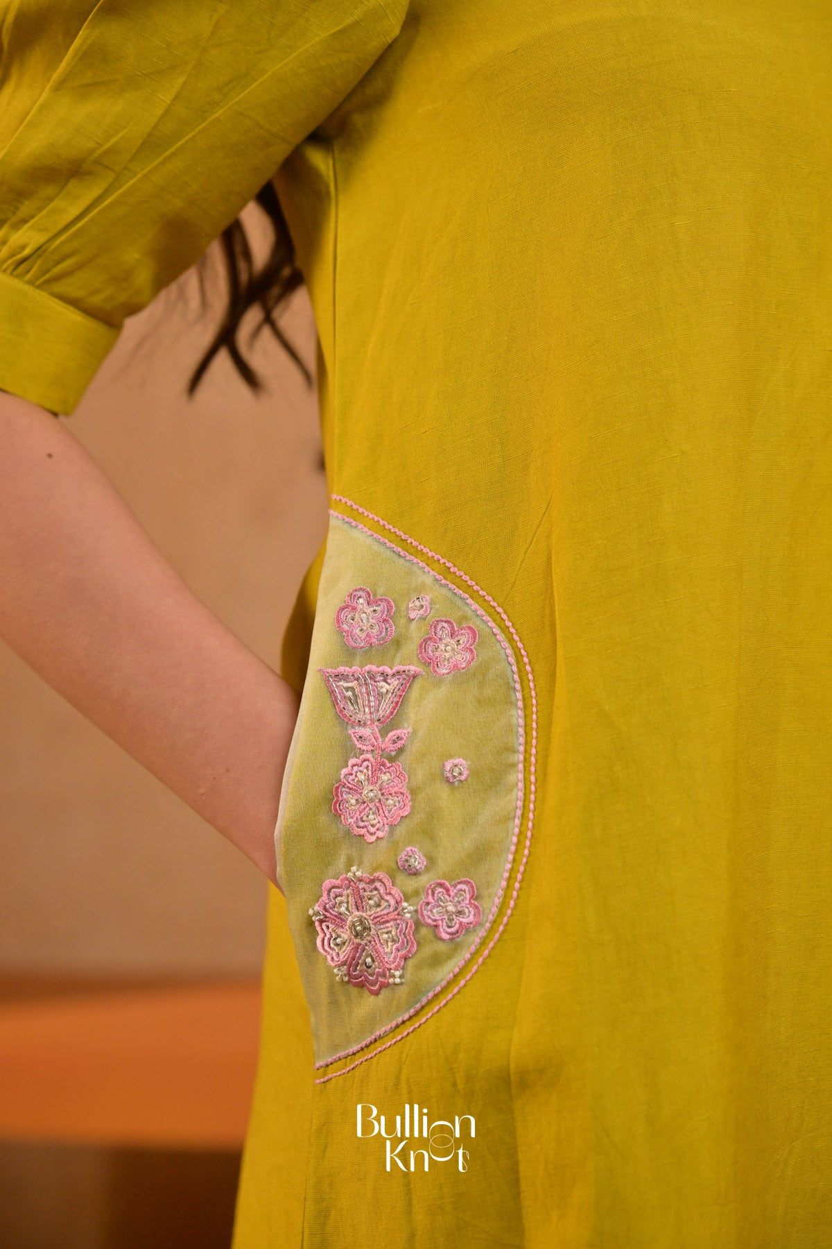 Close-up of embroidered pocket detail on yellow kurta