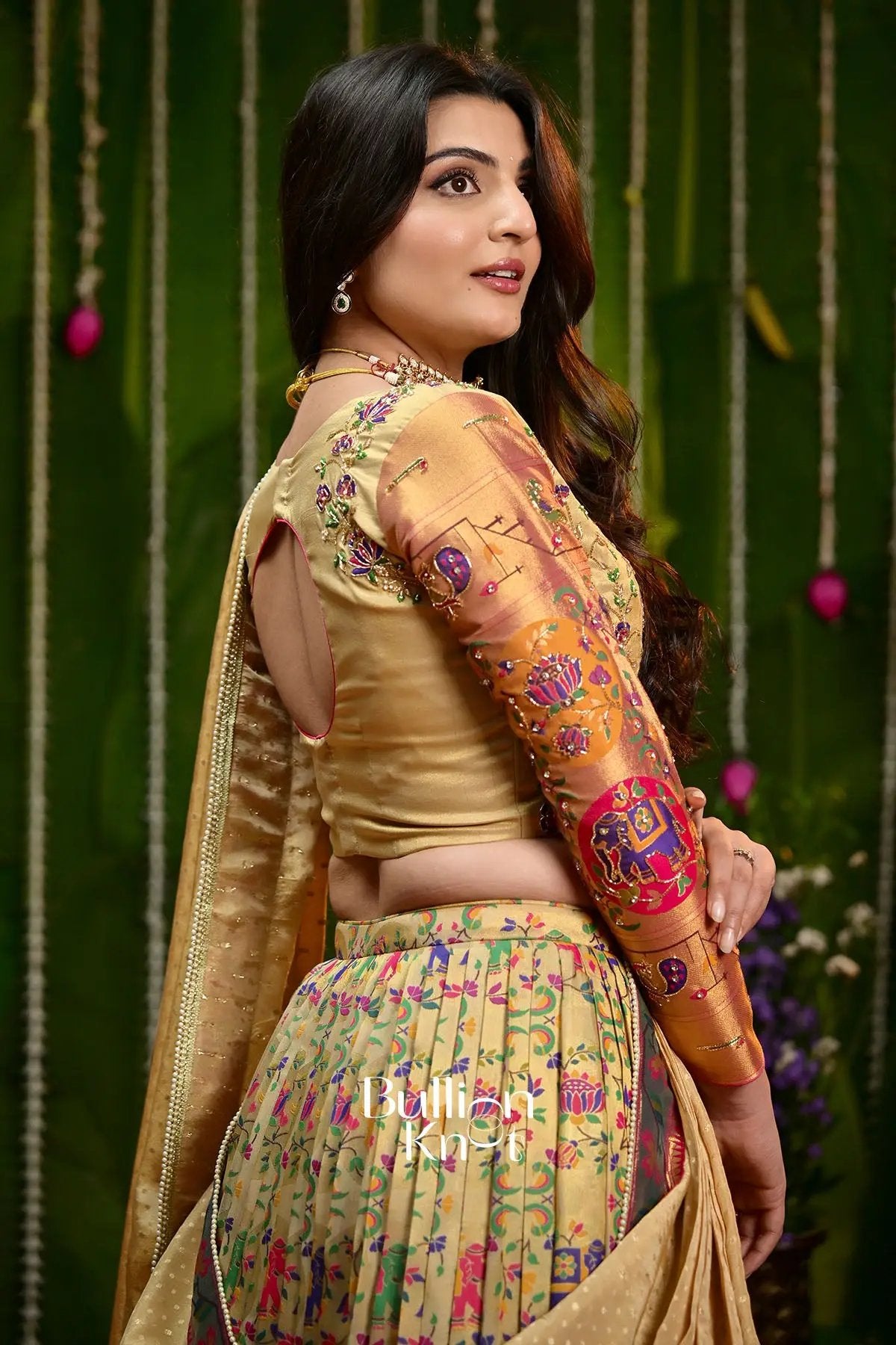 Woman in traditional gold and pink embroidered saree with jewelry