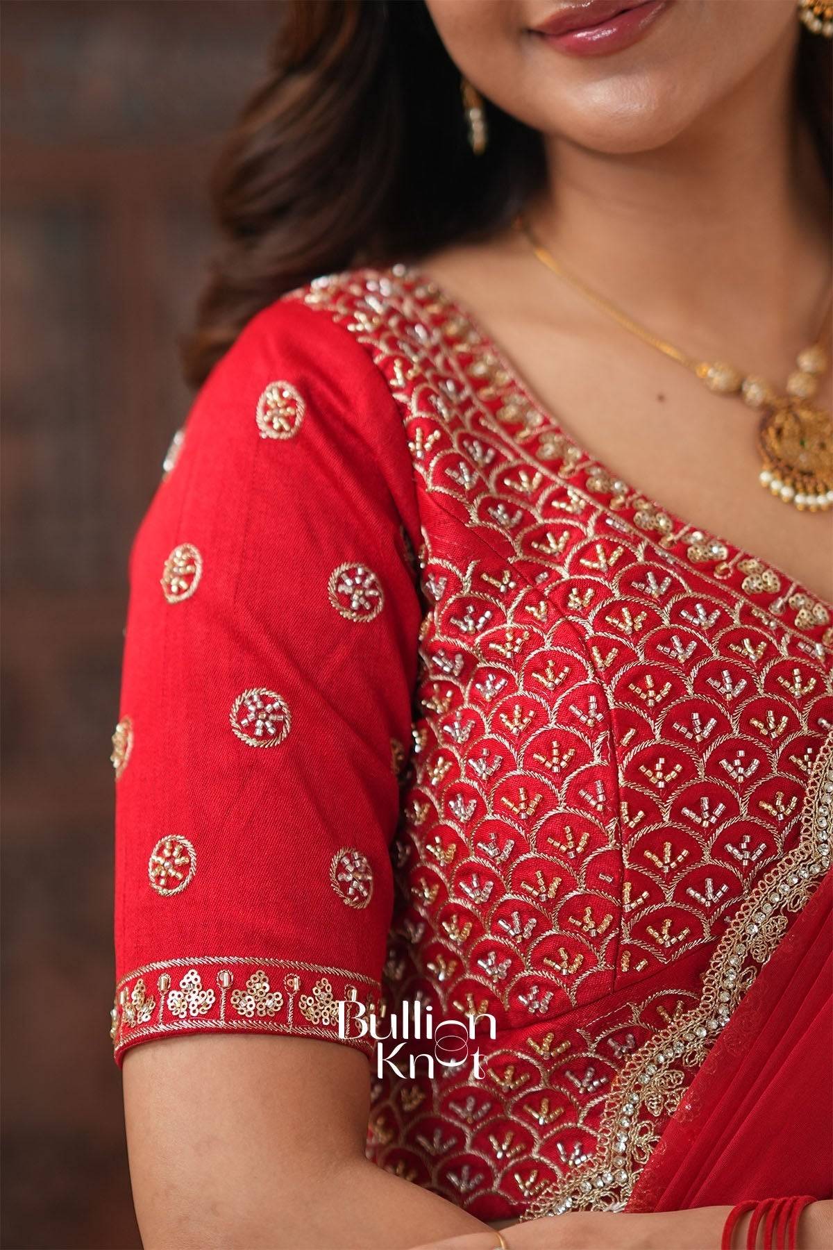 Close-up of red embroidered blouse with gold and silver thread work, traditional Indian ethnic wear