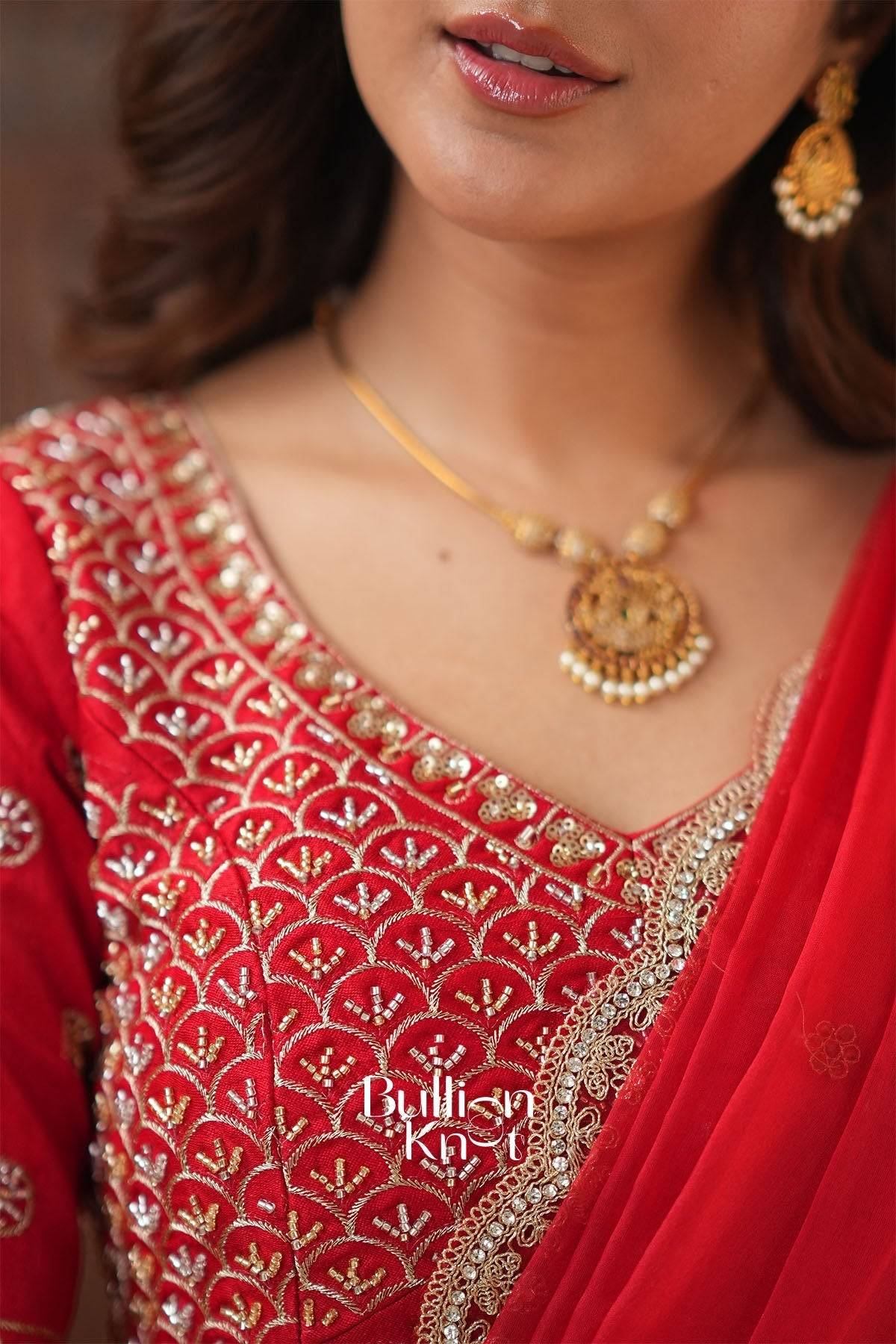 Red embroidered lehenga with gold and silver embellishments, traditional Indian attire for festive occasions