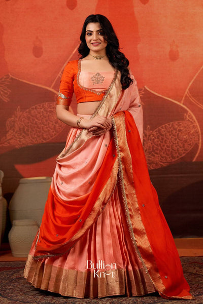 Exclusive Lehenga - Kaavya Dola Lehenga Set in Orange at bullionknot featuring a peach and orange silk blend with zari border, ideal for traditional events.