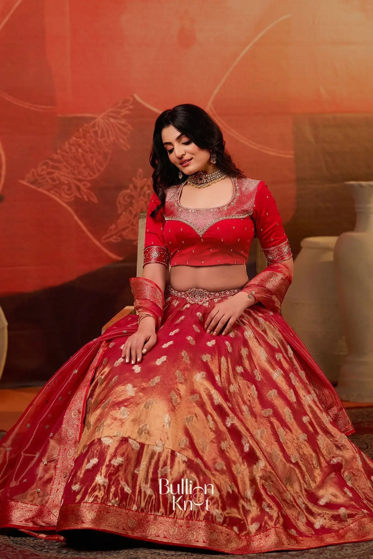 Exclusive Lehenga - Amulya Tissue Zari Lehenga Set in Red at bullionknot featuring a rich red blouse and gold zari embroidered skirt, ideal for weddings.