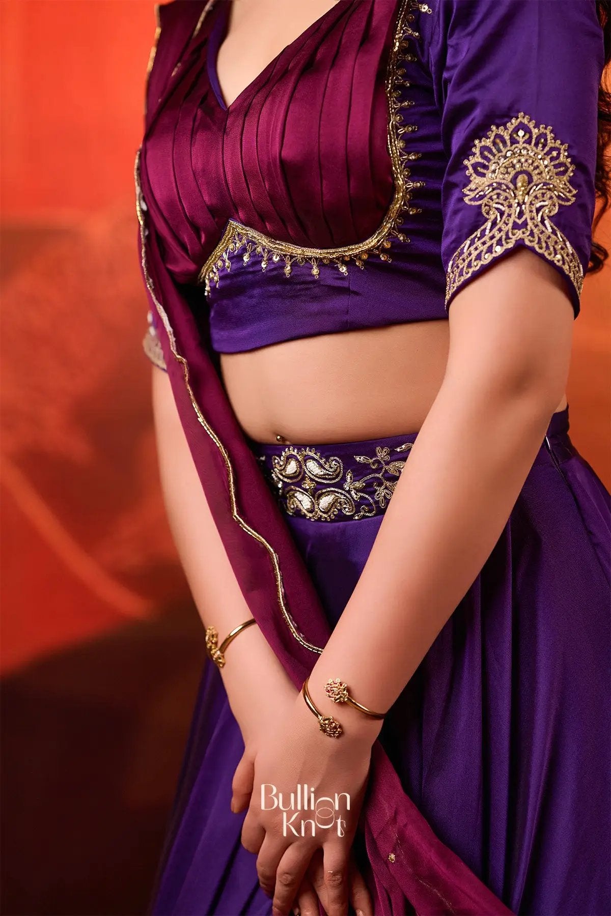 Close-up of Ariana Charm Lehenga Set in Purple at bullionknot showcasing intricate embroidery on the blouse and waistband for traditional elegance.