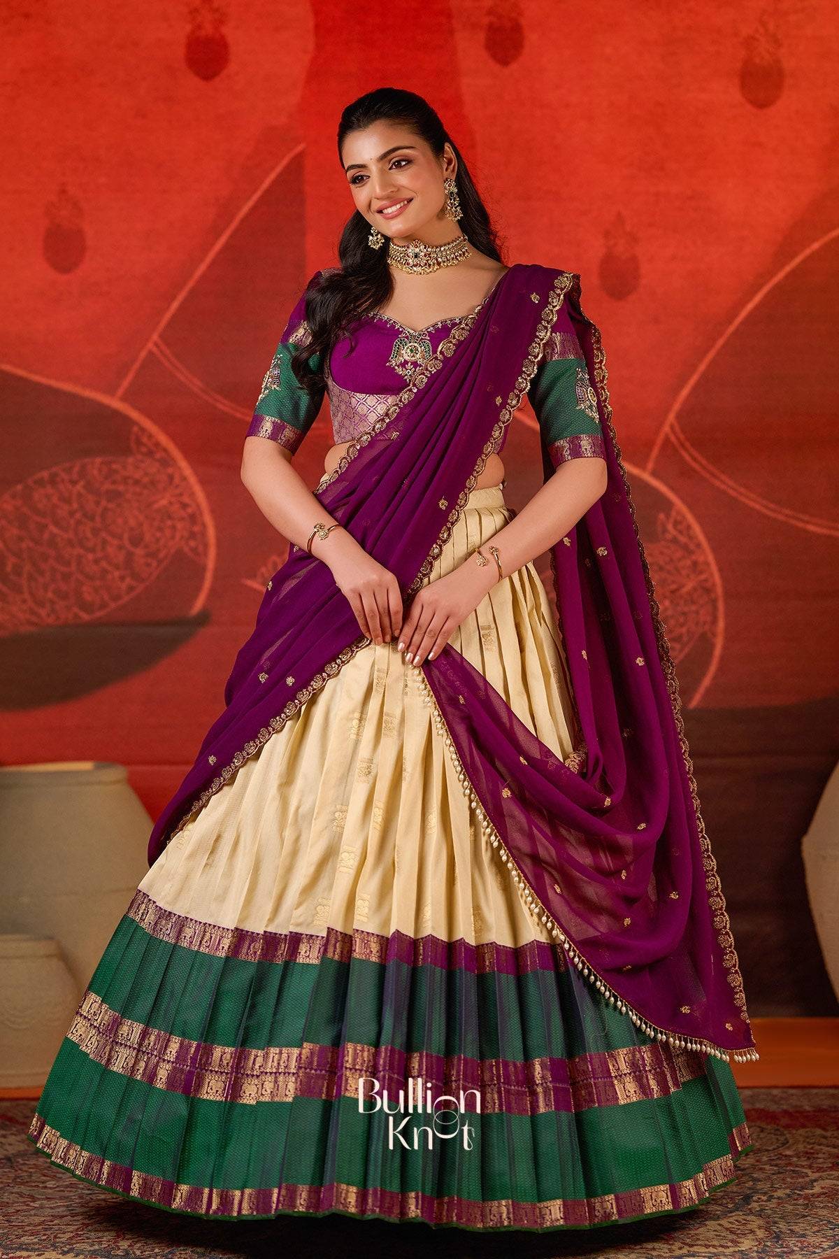 Exclusive Lehenga - Vishakha Half Saree in Vanilla at bullionknot featuring a vanilla pleated skirt with green and purple borders, paired with a purple dupatta.