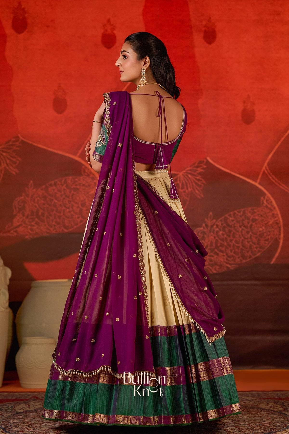 Back view of Exclusive Lehenga - Vishakha Half Saree in Vanilla at bullionknot, showcasing the deep back blouse design with tassel ties and embroidered dupatta.