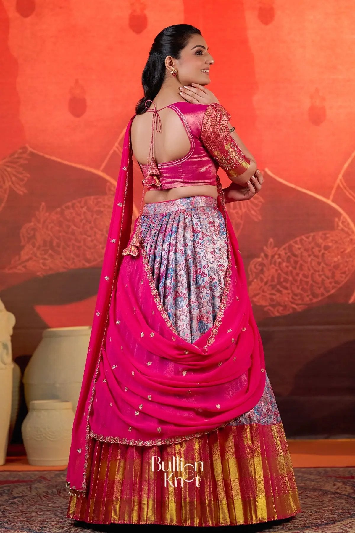 Back view of the Pranjal Silk Lehenga Set in Pink at bullionknot highlighting the tie-back blouse and flowing dupatta drape.