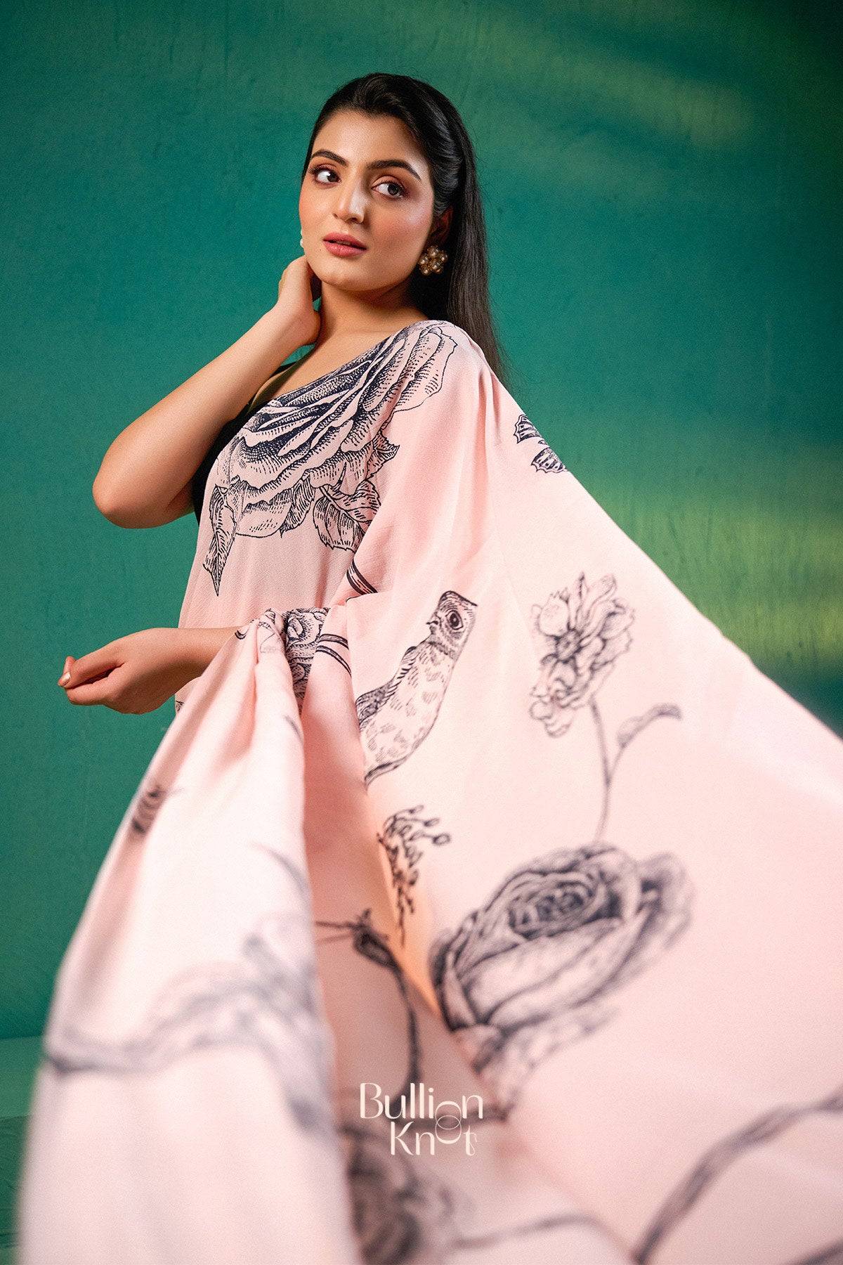 Bullionknot's Exclusive Sarees - Sreeleela Saree in Pastel Pink with artistic bird and rose prints, ideal for summer-ready ethnic fashion statements.