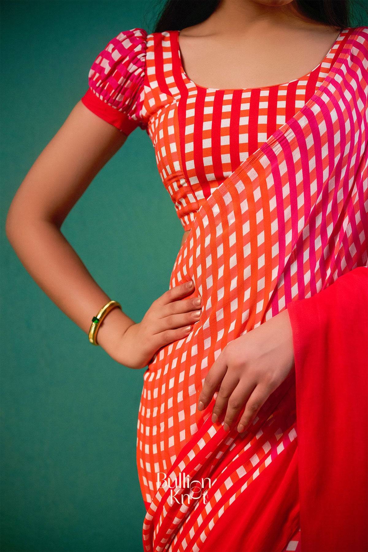 Close-up of Nargis Saree in Orange at bullionknot showing detailed red and white checkered design with matching blouse, perfect for summer saree collections.