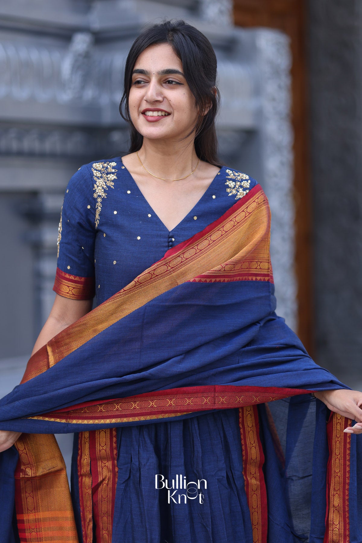 Woman wearing a blue and orange saree with a blurred background