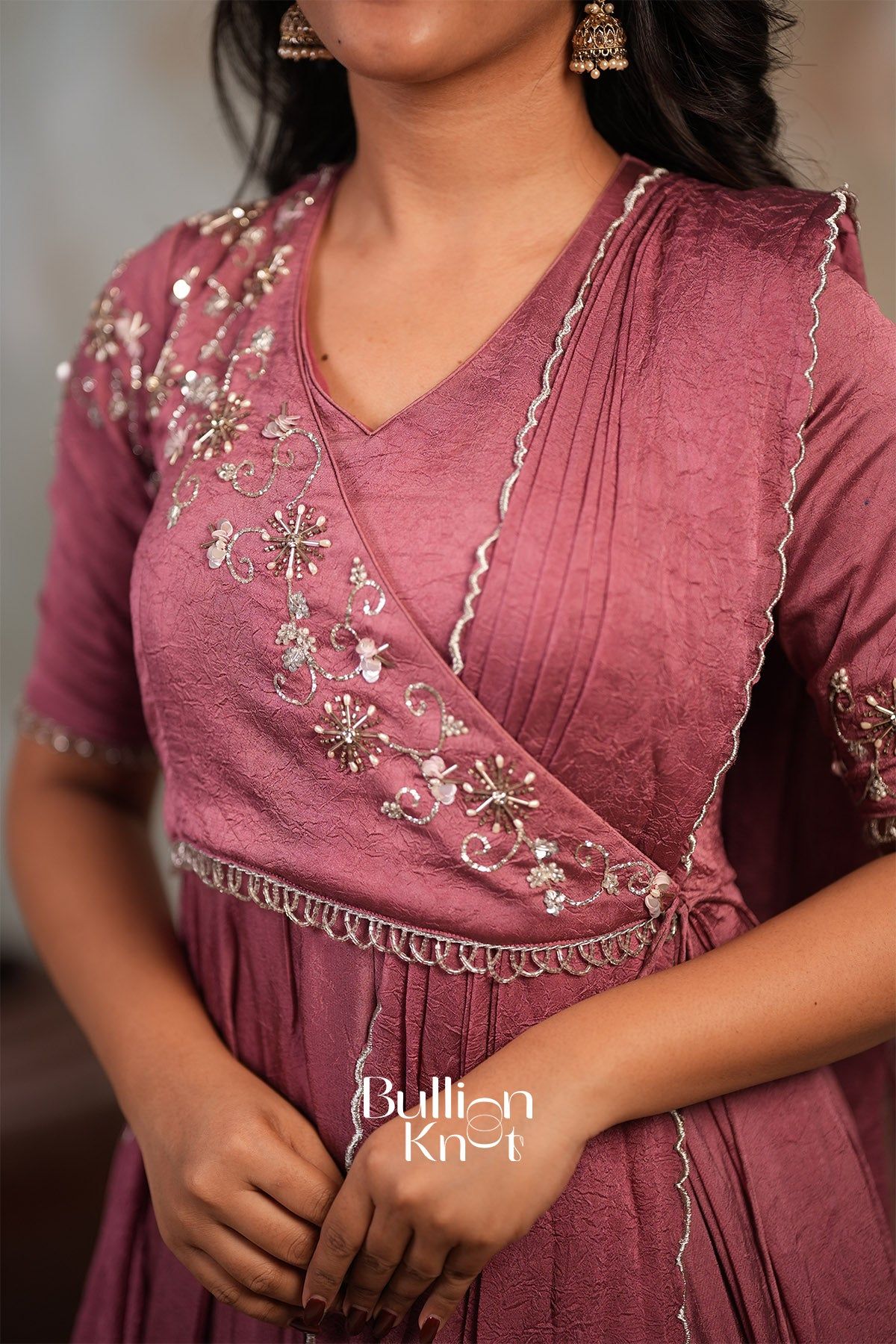 Close-up of pink embroidered silk long gown with detailed embellishments