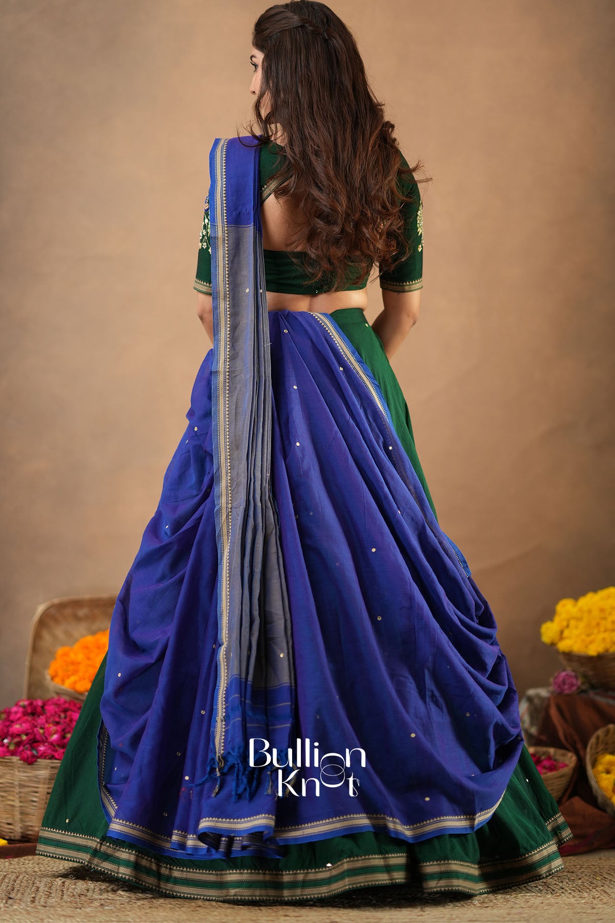Woman wearing a blue and green saree with a blurred background