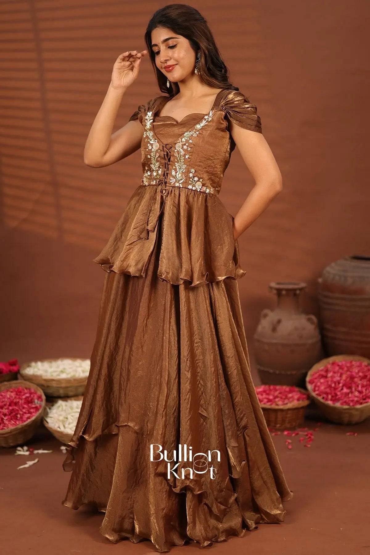 Elegant brown gown with embroidered floral details and ruffled skirt, perfect for festive events