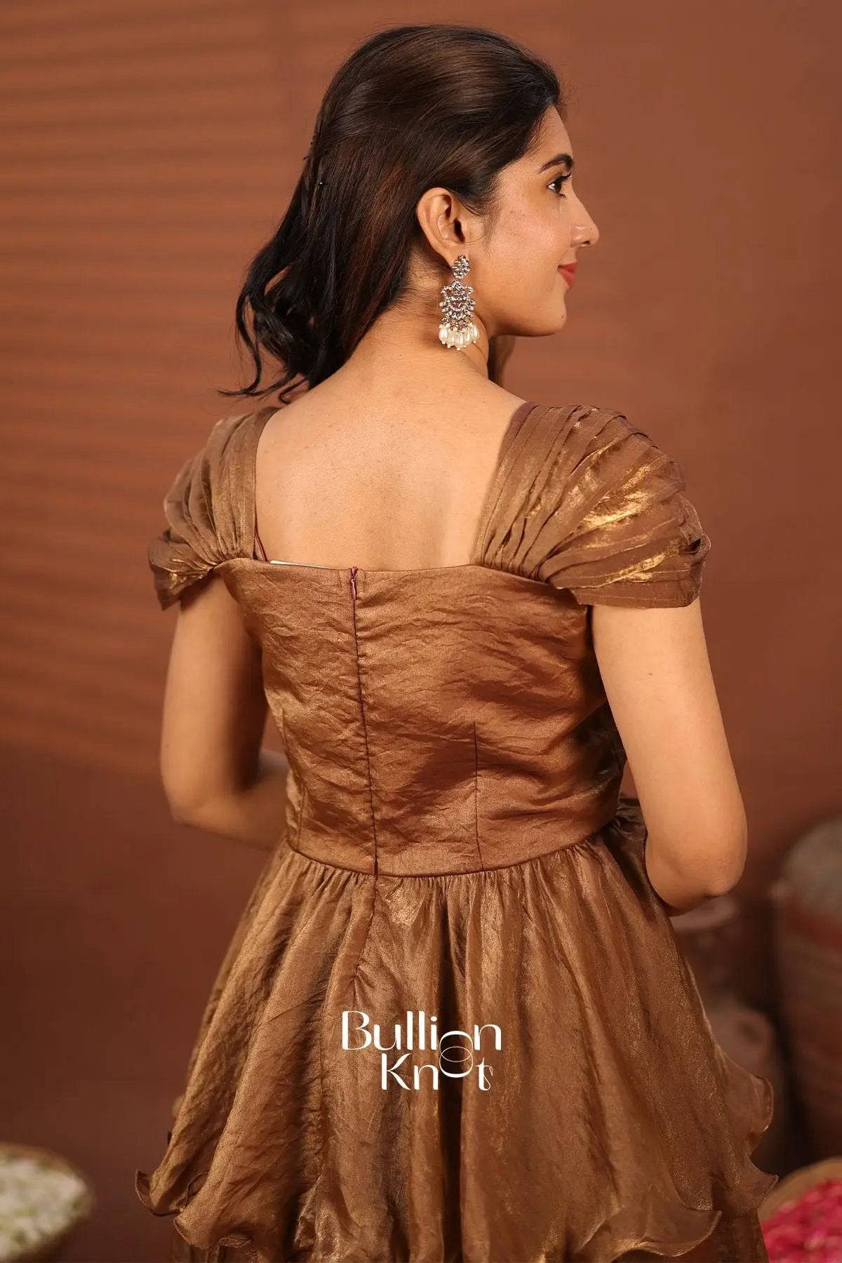 Side view of brown satin Indowestern gown with ruffled hem and floral embroidery