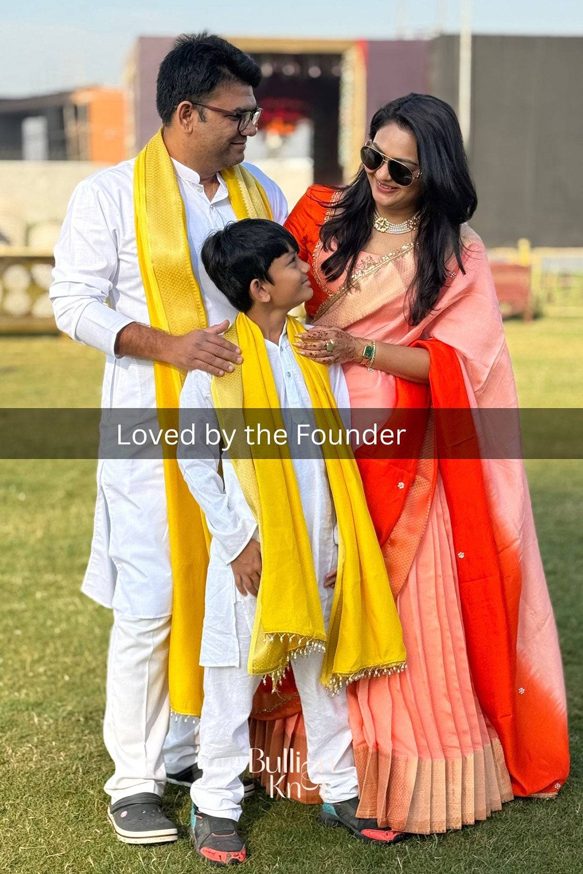 Family wearing the Kaavya Dola Lehenga Set in Orange at bullionknot, showcasing its festive elegance and cultural charm for ceremonial occasions.