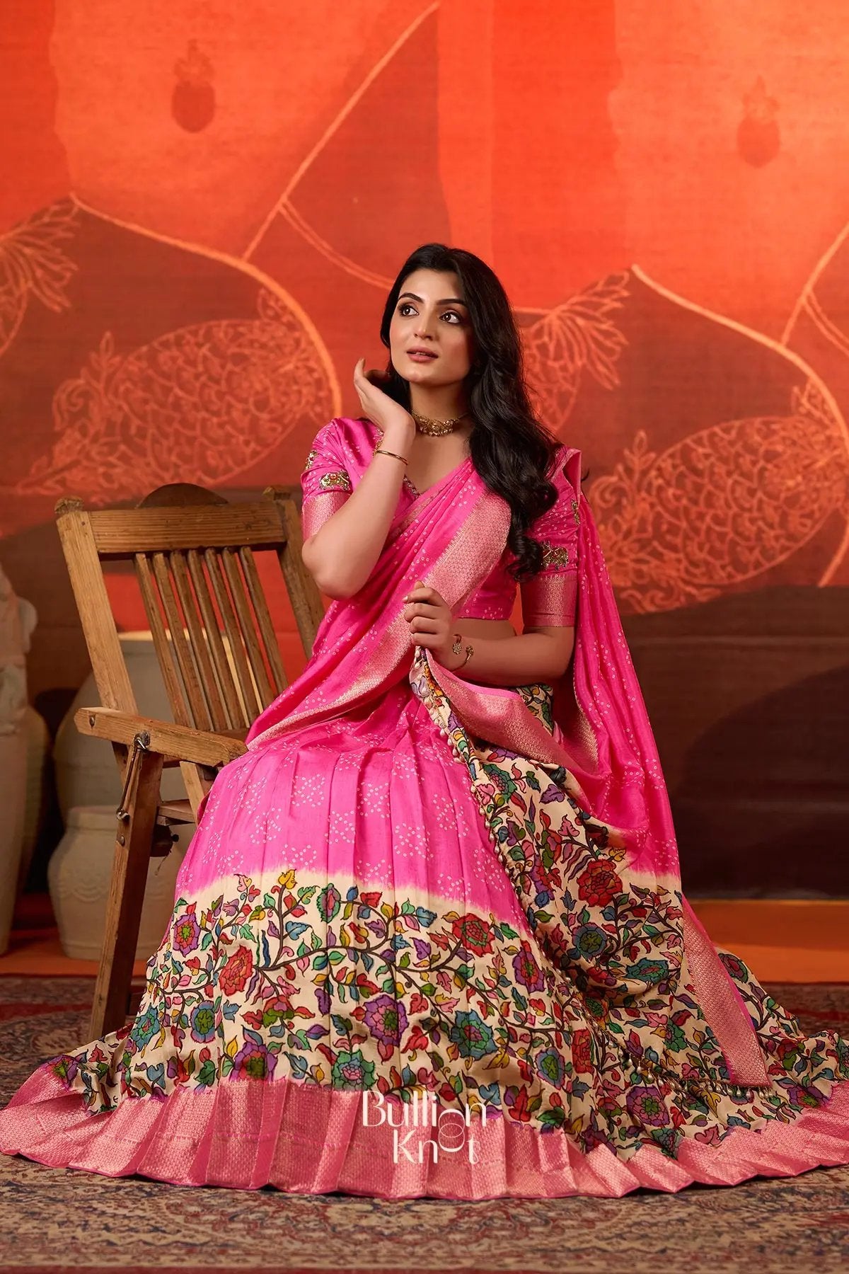 Seated pose in Gokulika Lehenga Set In Pink at bullionknot featuring elegant styling and vibrant ethnic design for exclusive traditional wear.