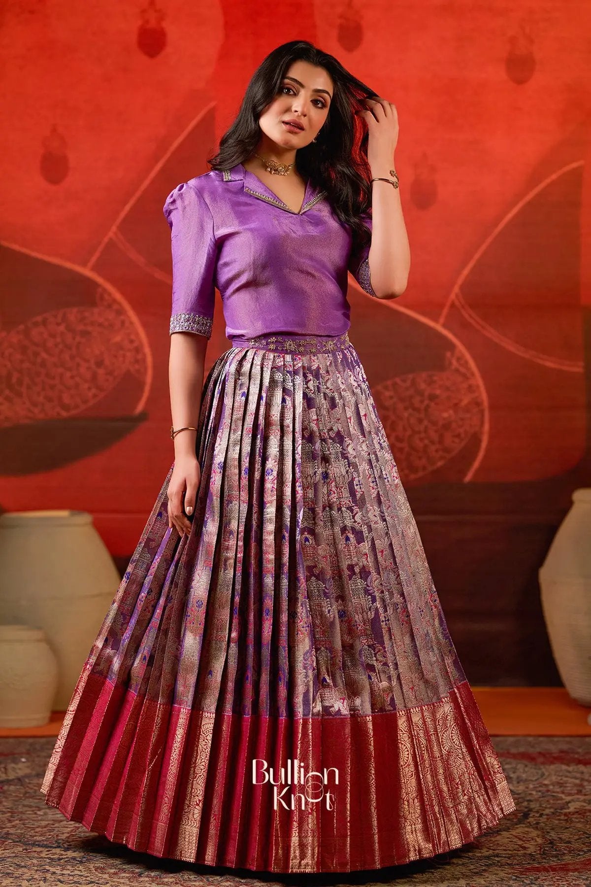 Azaira Indo Western Lehenga in Red at bullionknot styled with a rich purple top and traditional pleated skirt, perfect for ceremonial occasions.