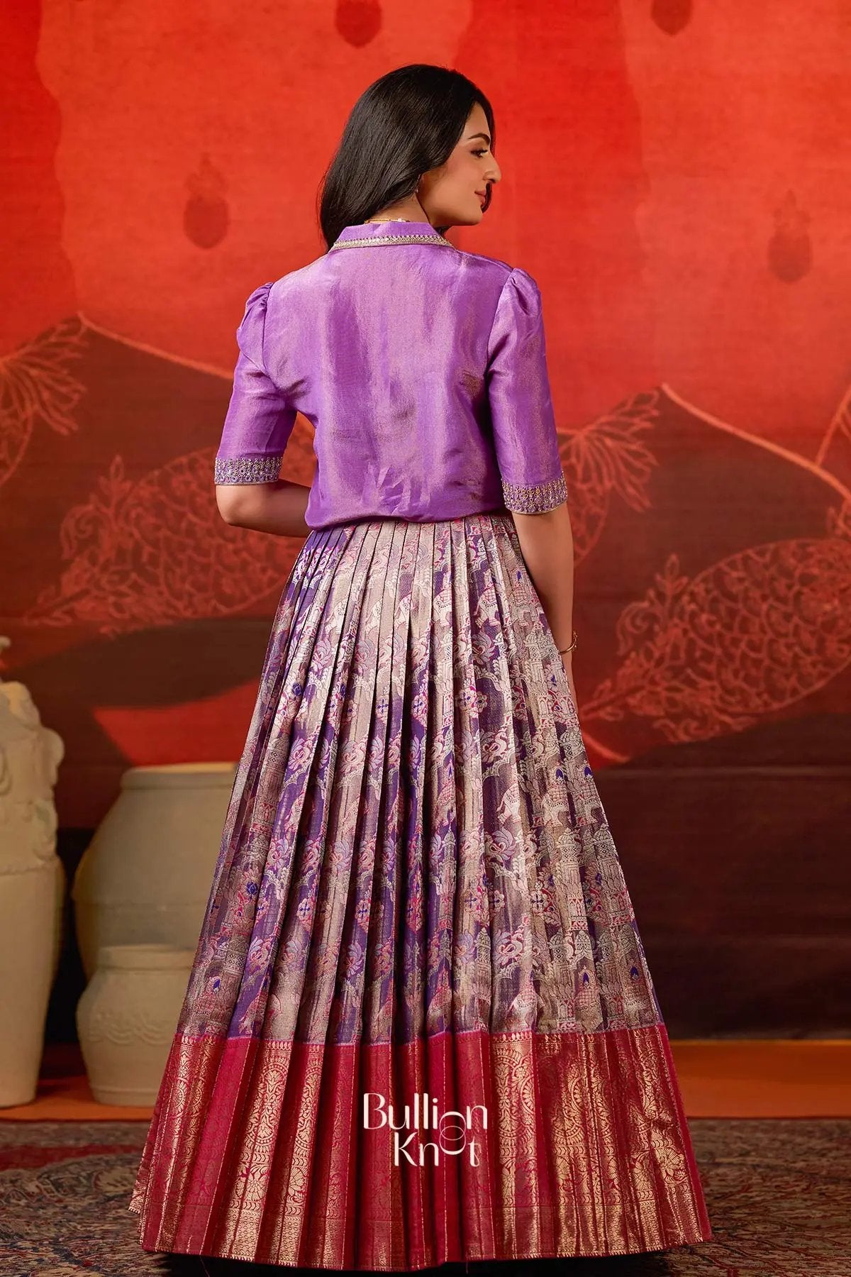 Back view of Azaira Indo Western Lehenga in Red at bullionknot highlighting blouse design and full pleated skirt with red border.