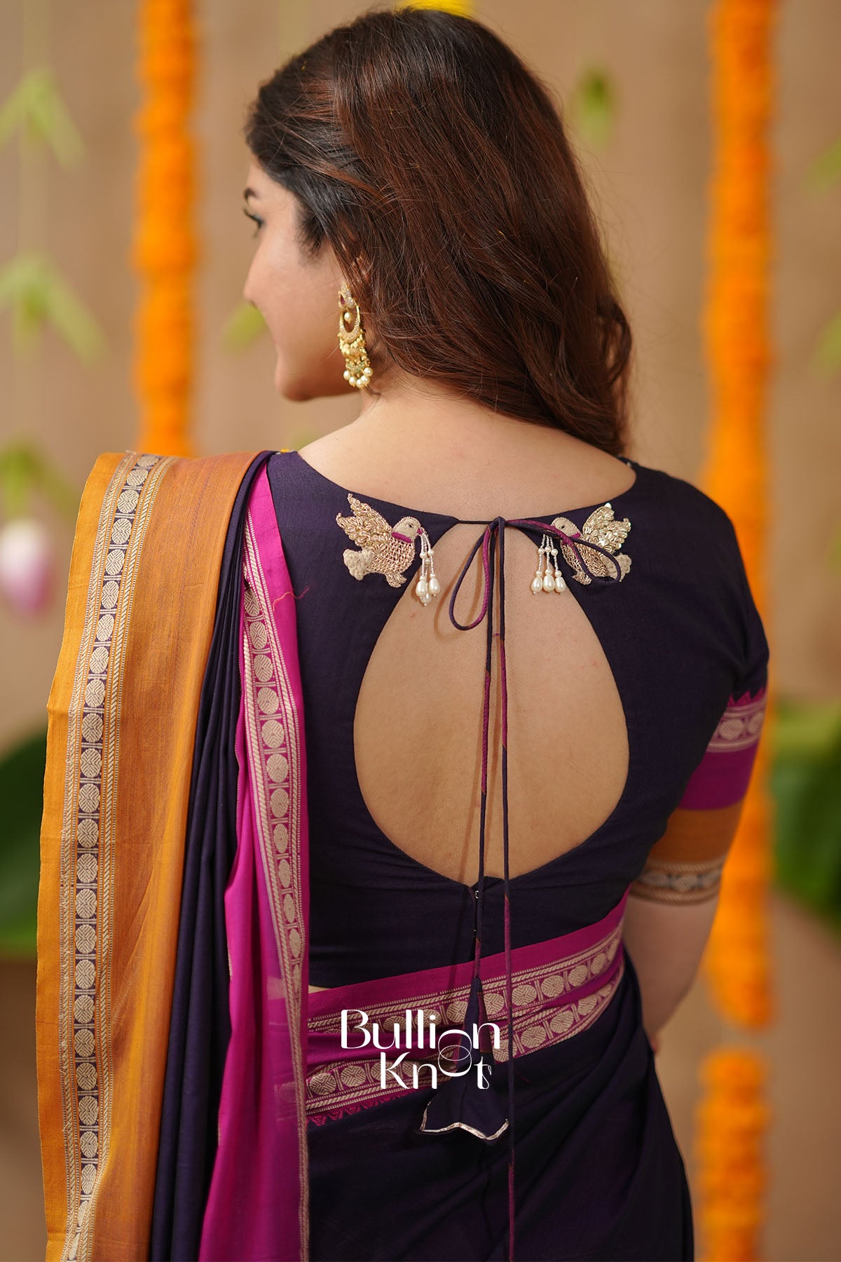 Woman wearing a dark blue saree with floral patterns