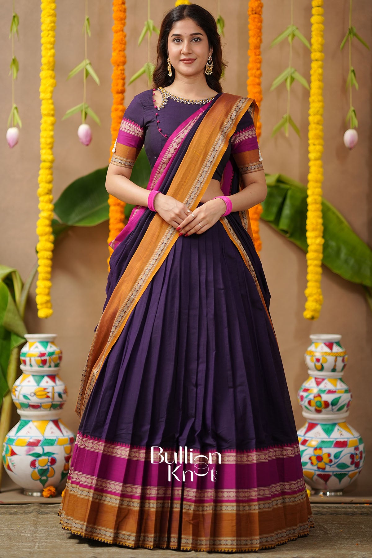 Woman wearing a traditional purple and orange saree