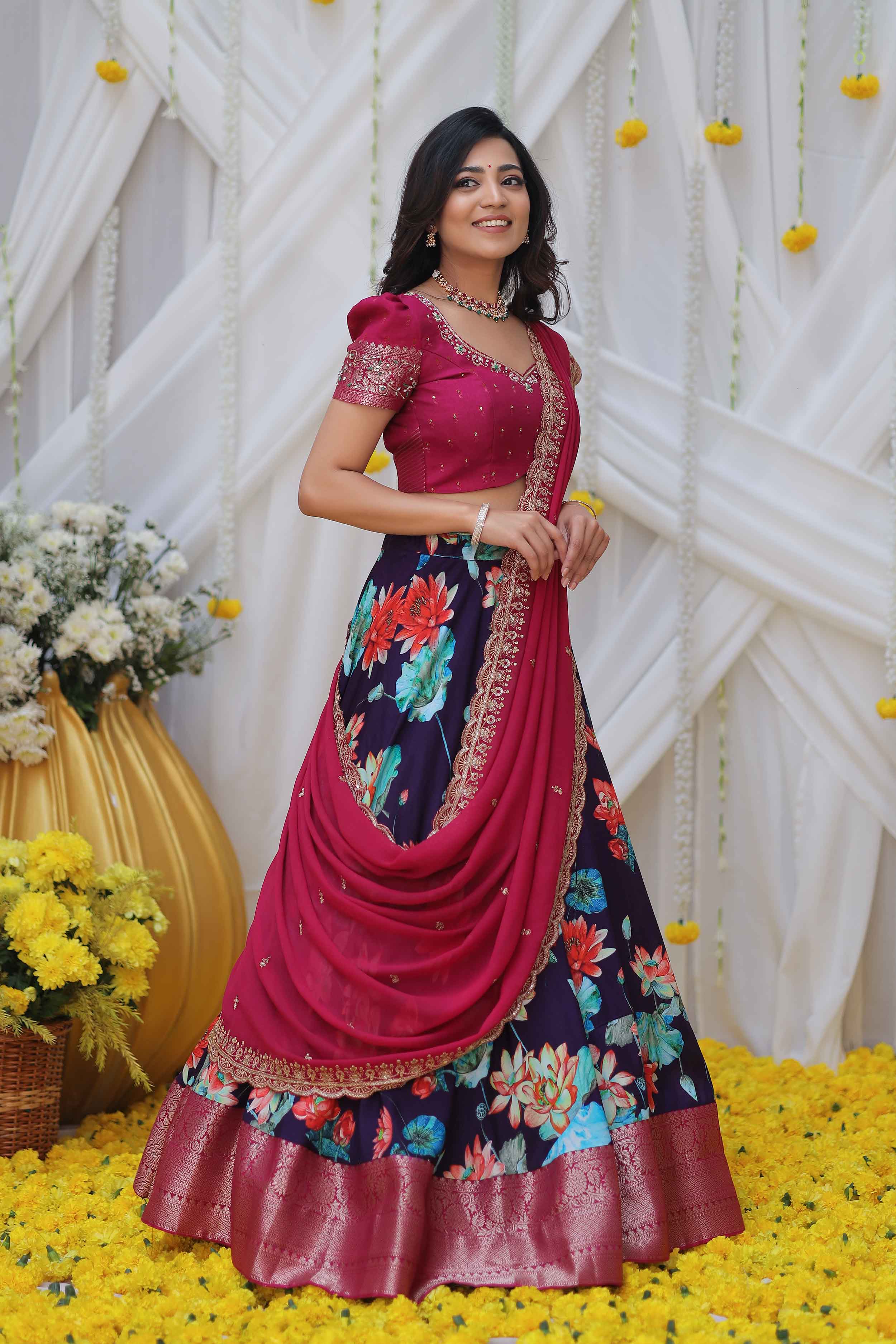 a woman in magenta and purple half saree