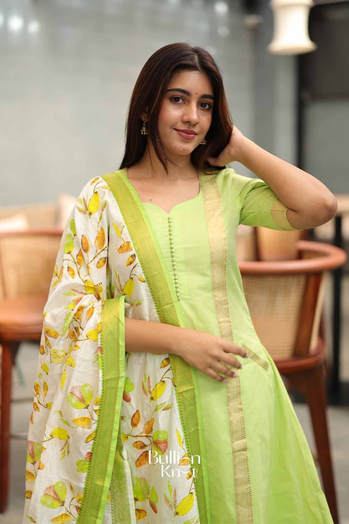 Close-up of the lime green A-line suit top with fabric-covered buttons, showcasing the elegant neckline and detailed stitching.