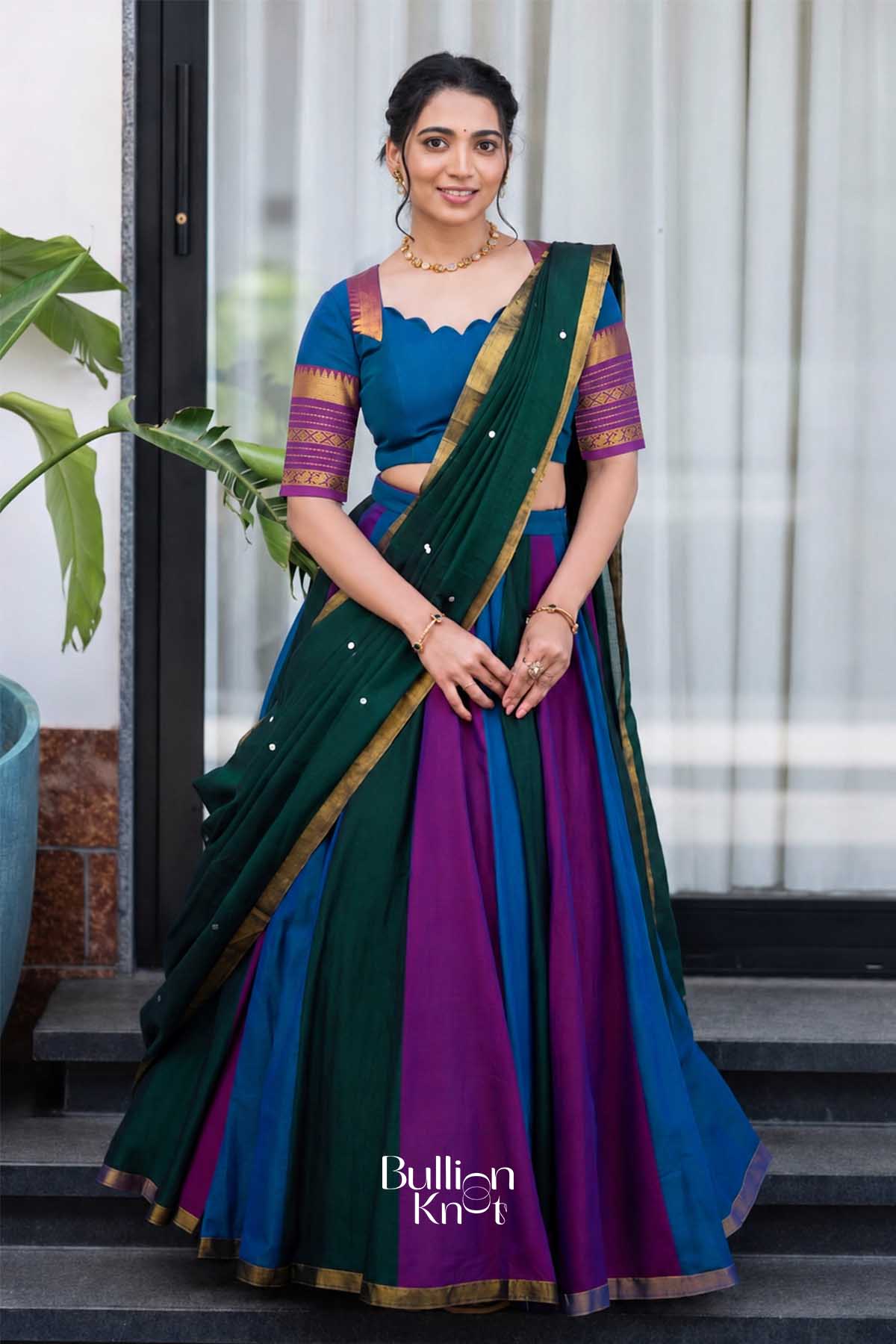 Elegant woman wearing a multicolor handloom half saree in blue, purple, and green with gold border, styled for festive celebration.
