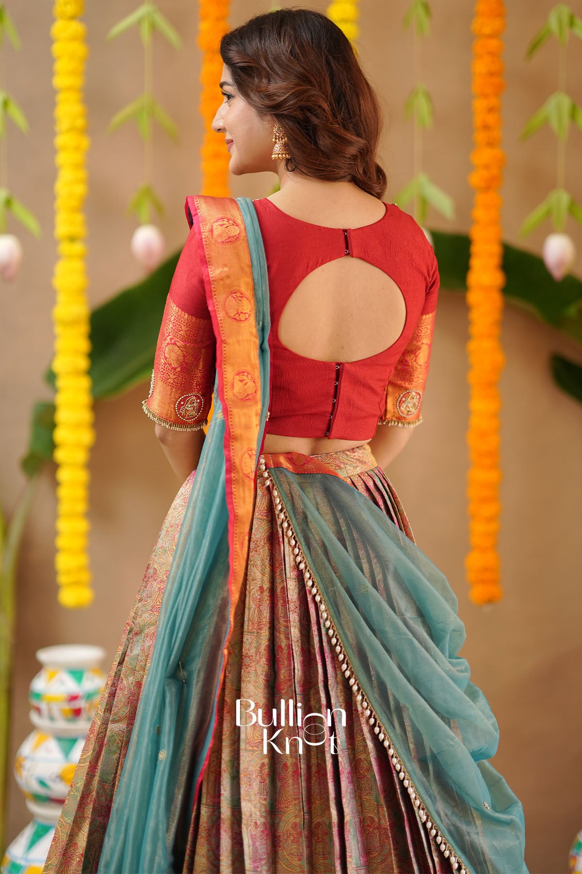 Red Silk Lehenga Set with golden detailing and matching Potli Purse – back view.