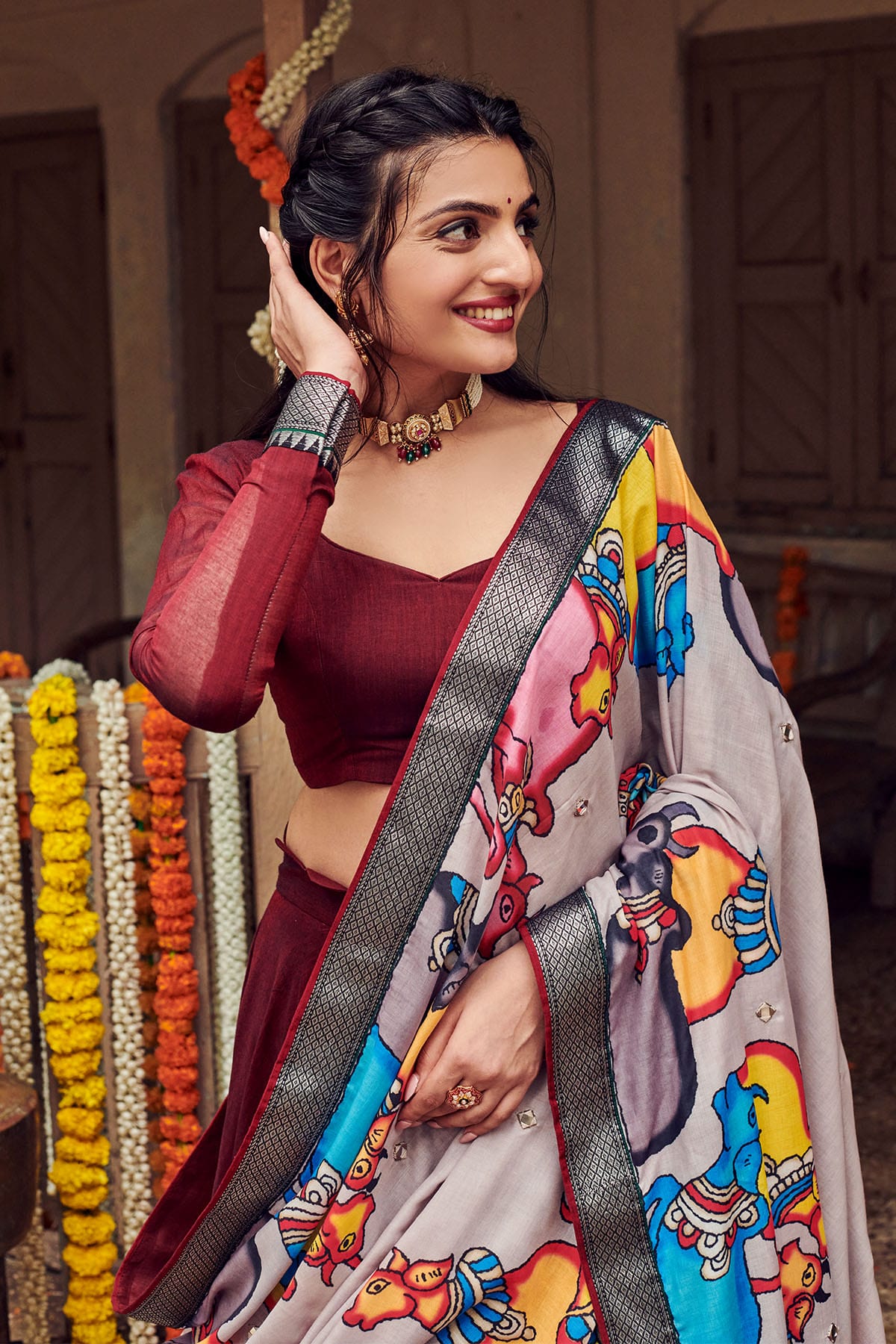 a women posing in dark maroon handloom lehenga dress with cotton dupatta, dress name Shisha kalamkari Lehenga Set