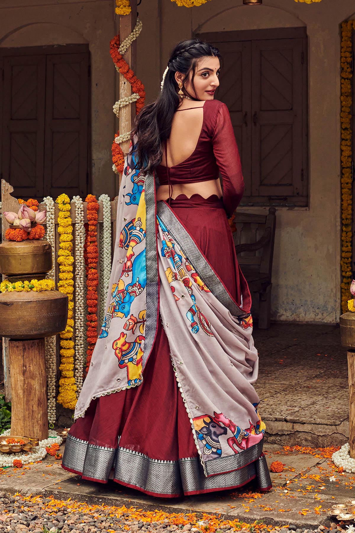 a model with dark maroon handloom lehenga dress with cotton dupatta, dress name Shisha kalamkari Lehenga Set