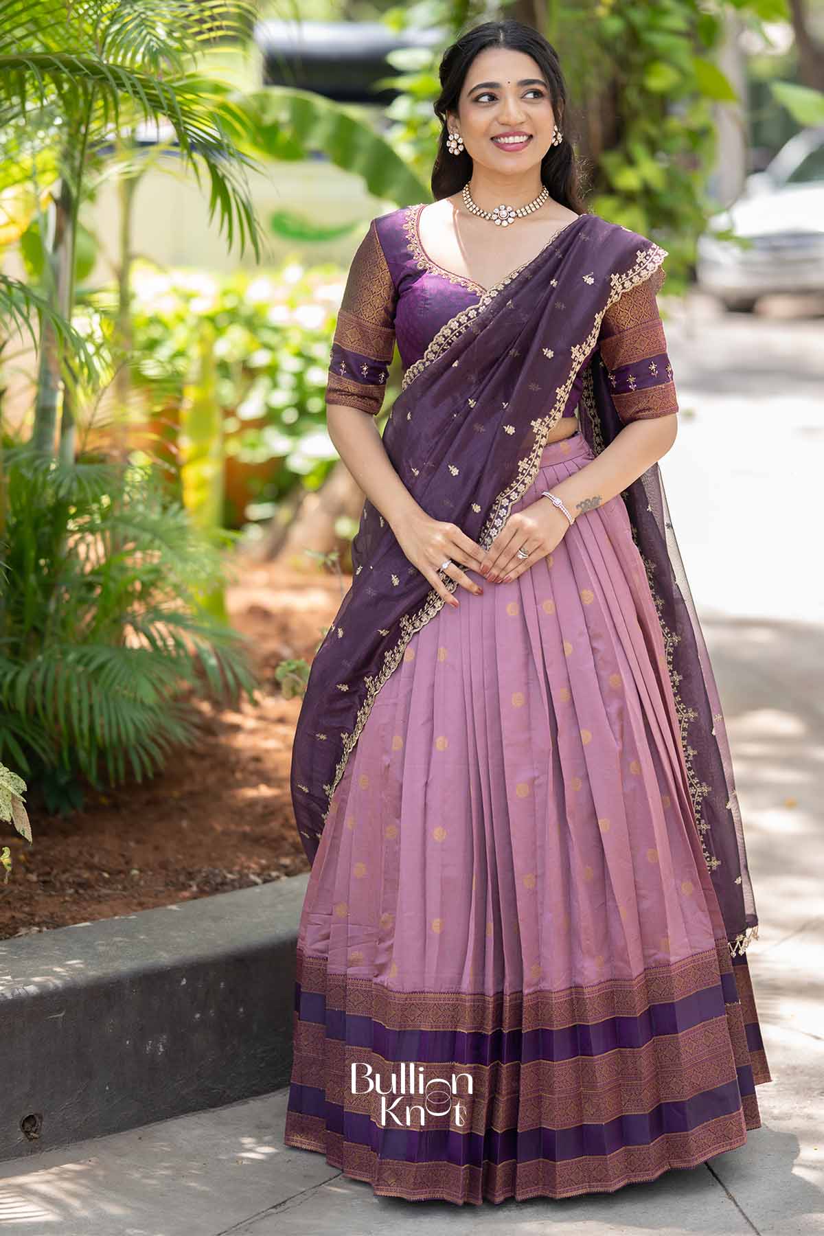 Elegant purple and pink silk lehenga with gold embroidery, matching blouse with 3/4 sleeves, traditional jewelry, perfect for festive occasions
