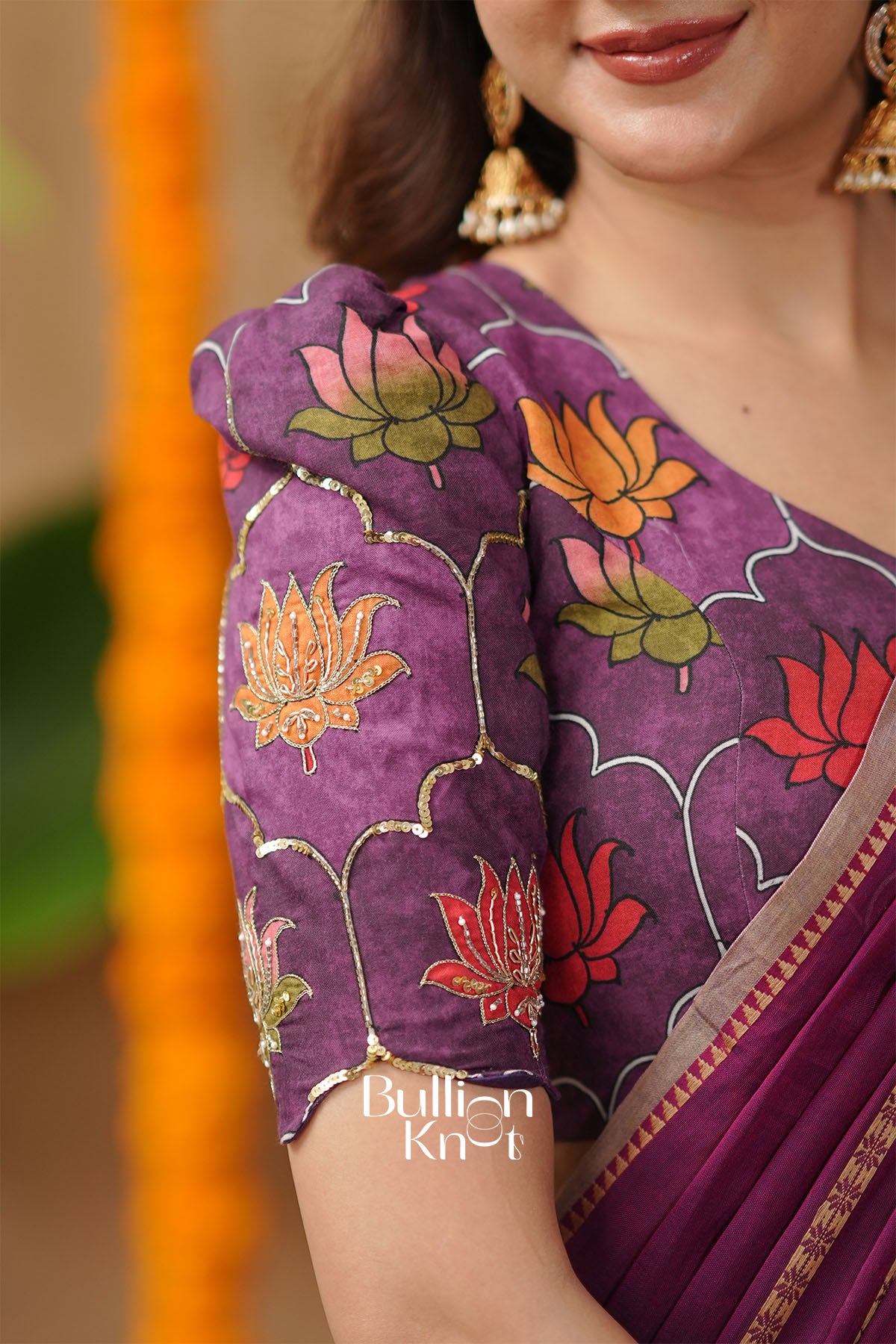 Purple saree with floral patterns worn by a person,