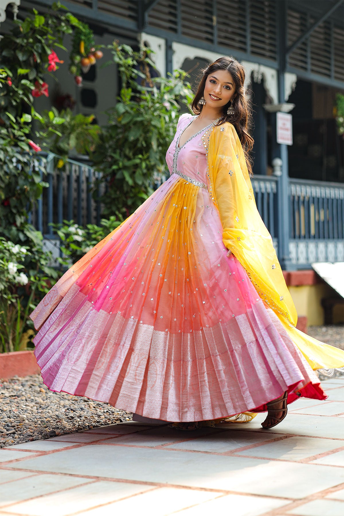 model dancing in an Anarkali Suit with pink and orange shade
