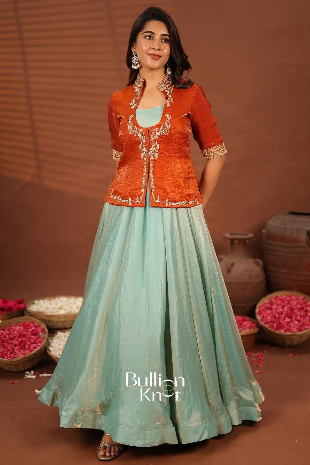 TV actress in orange embroidered jacket with pastel green saree