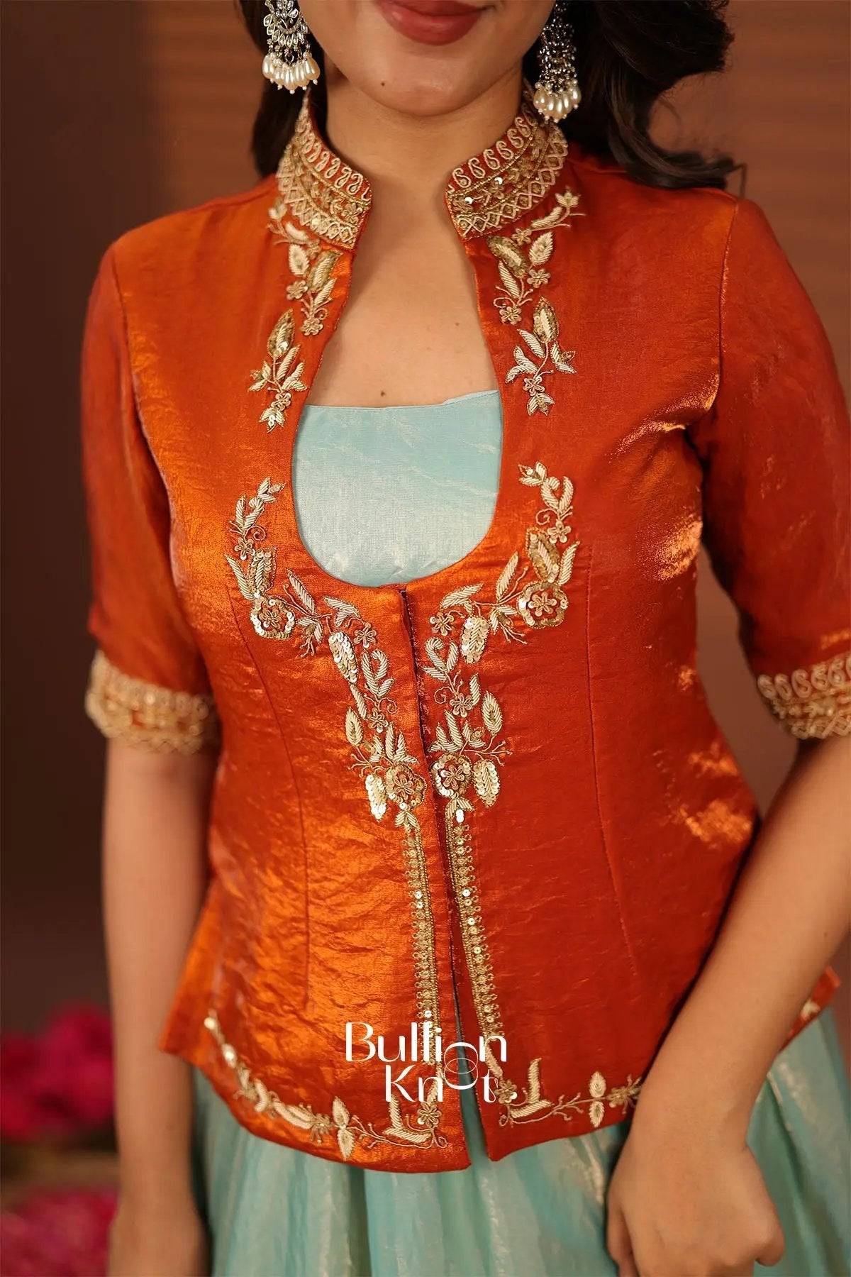 Close-up of orange indowestern dress with embroidered collar and sleeve cuffs