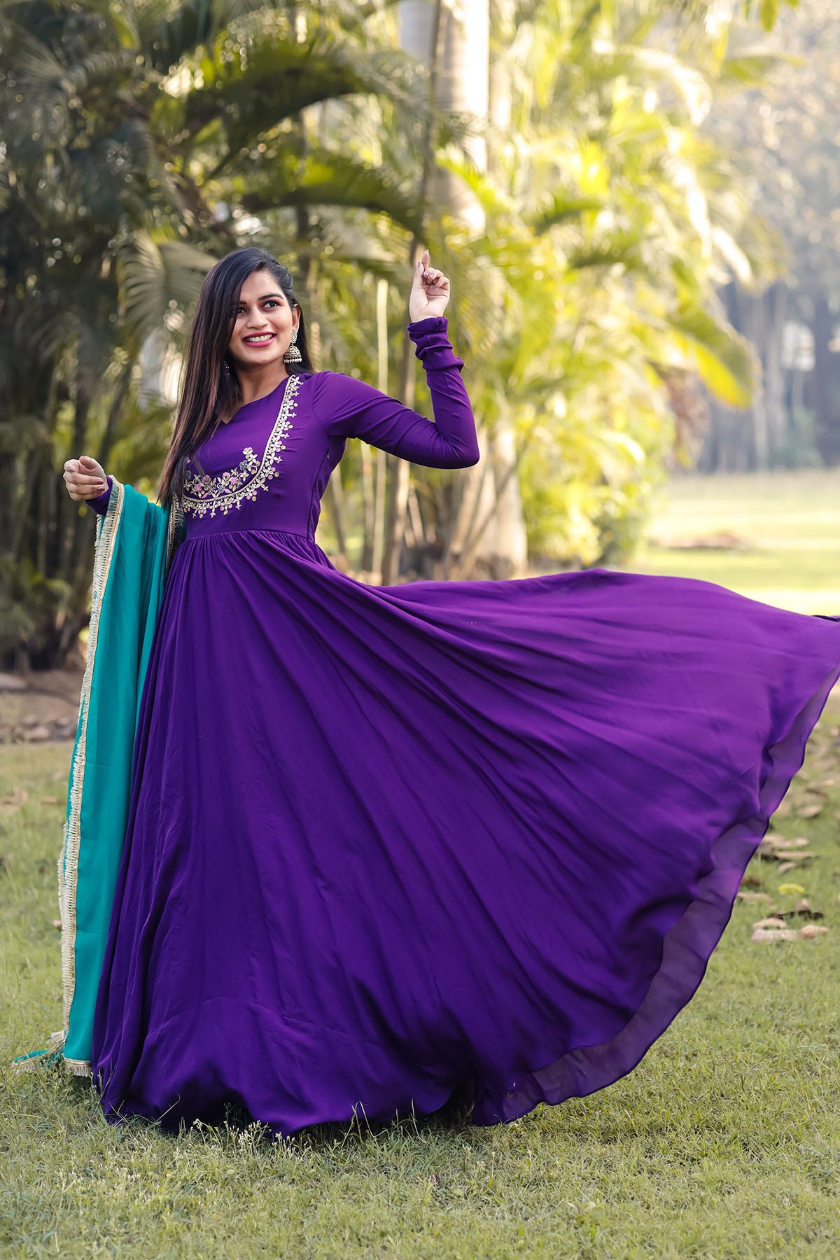 a woman in a long purple dress posing for a picture