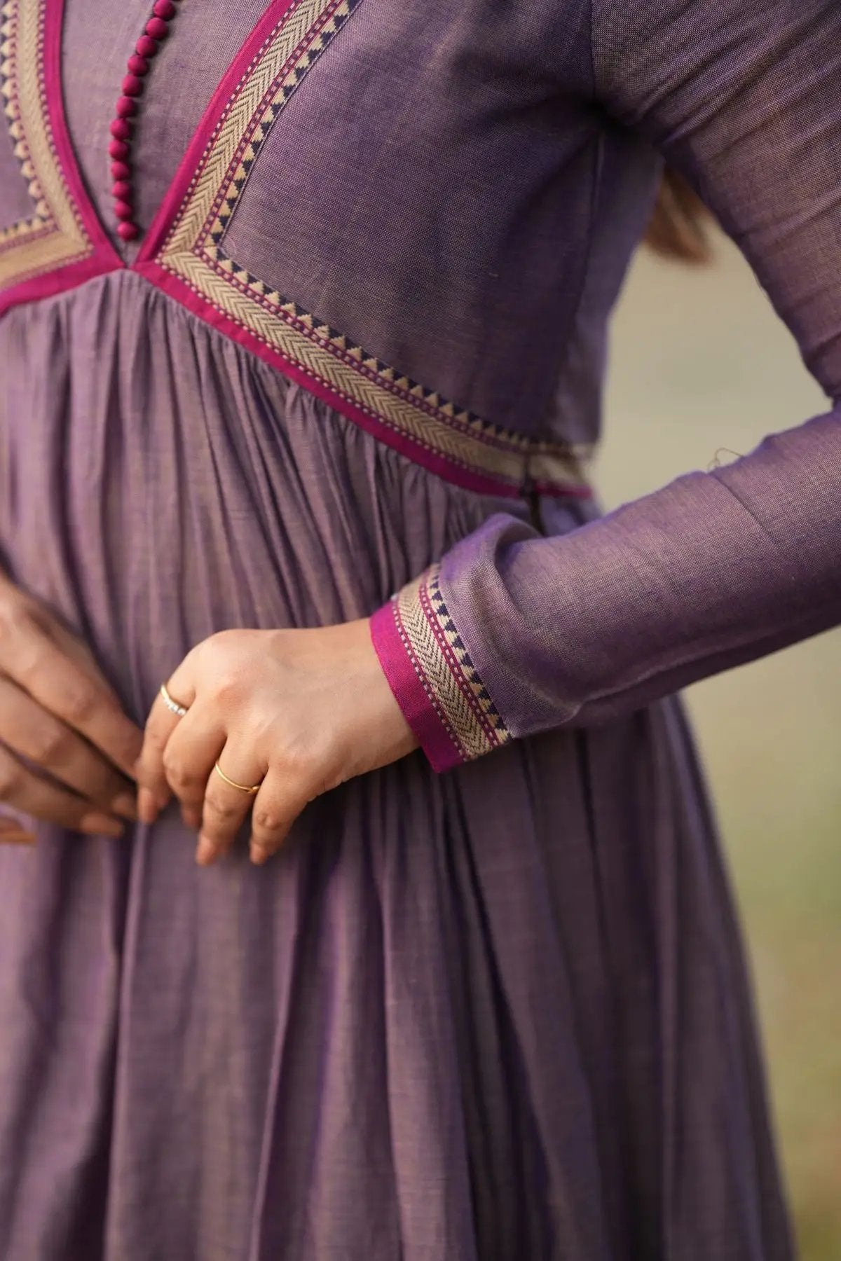 Close-up of Lipika Kurta Set in greyish lavender showcasing intricate pink and gold embroidery on the sleeves and bodice, perfect for ethnic occasions.