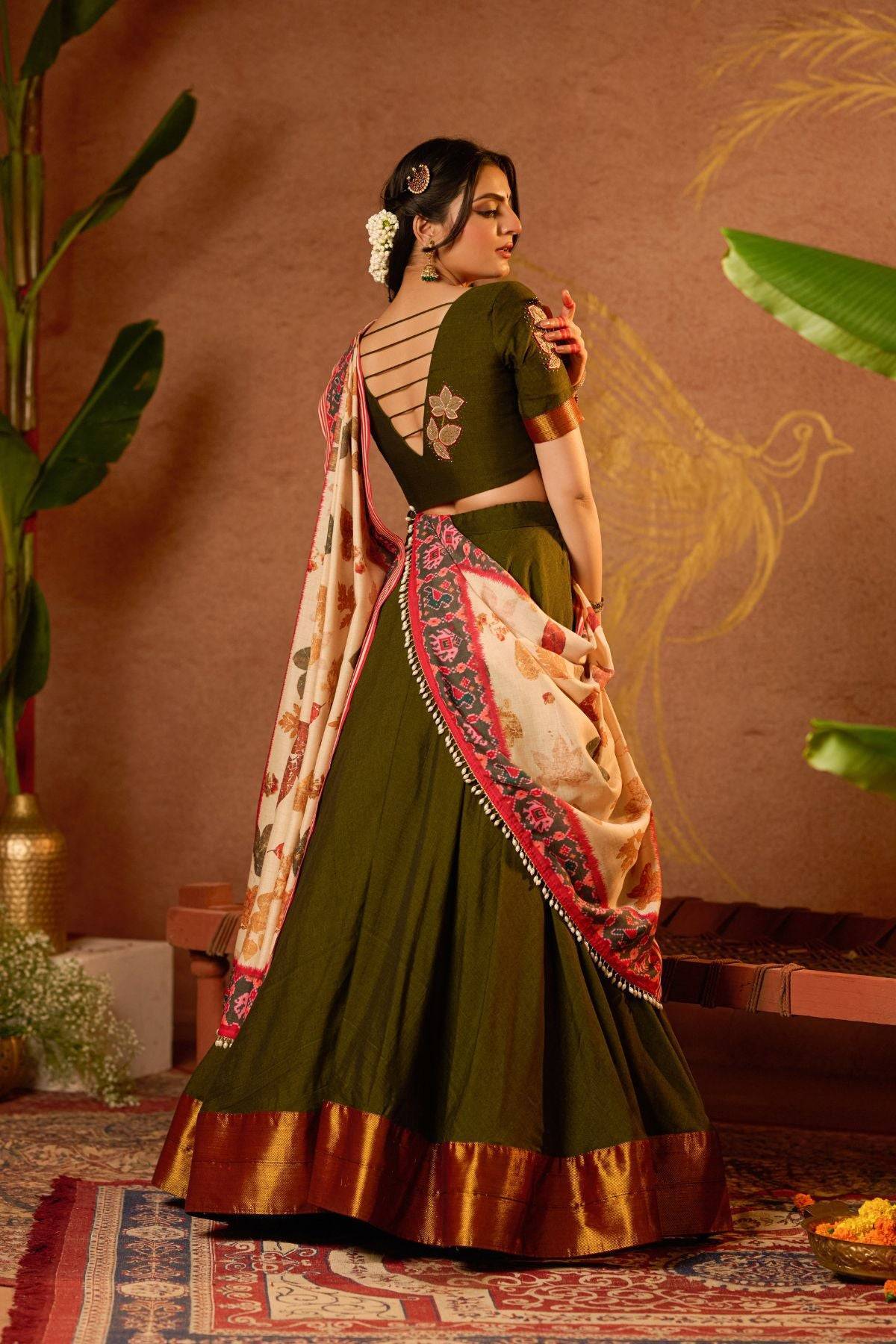 Back view of Tithi Lehenga Set in Mehendi at bullionknot with strappy blouse design and floral dupatta. Perfect for weddings and cultural celebrations.