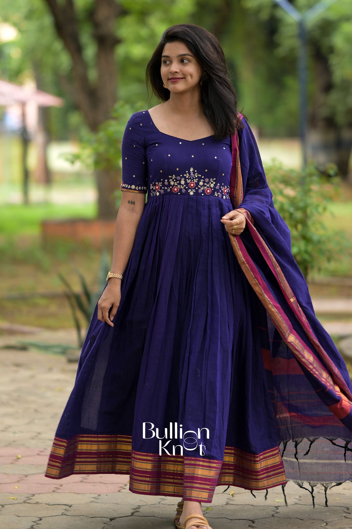  dark blue traditional outfit with a patterned dupatta in an outdoor setting.