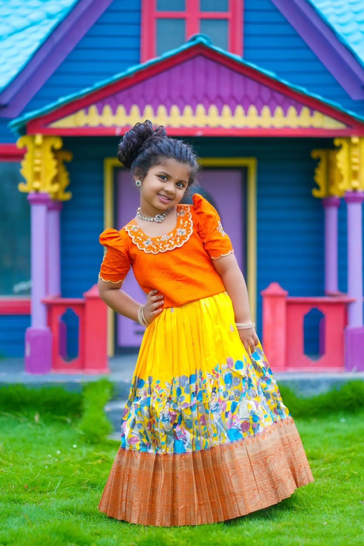 Girl in orange Baby Swathi Lehenga Set posing outdoors