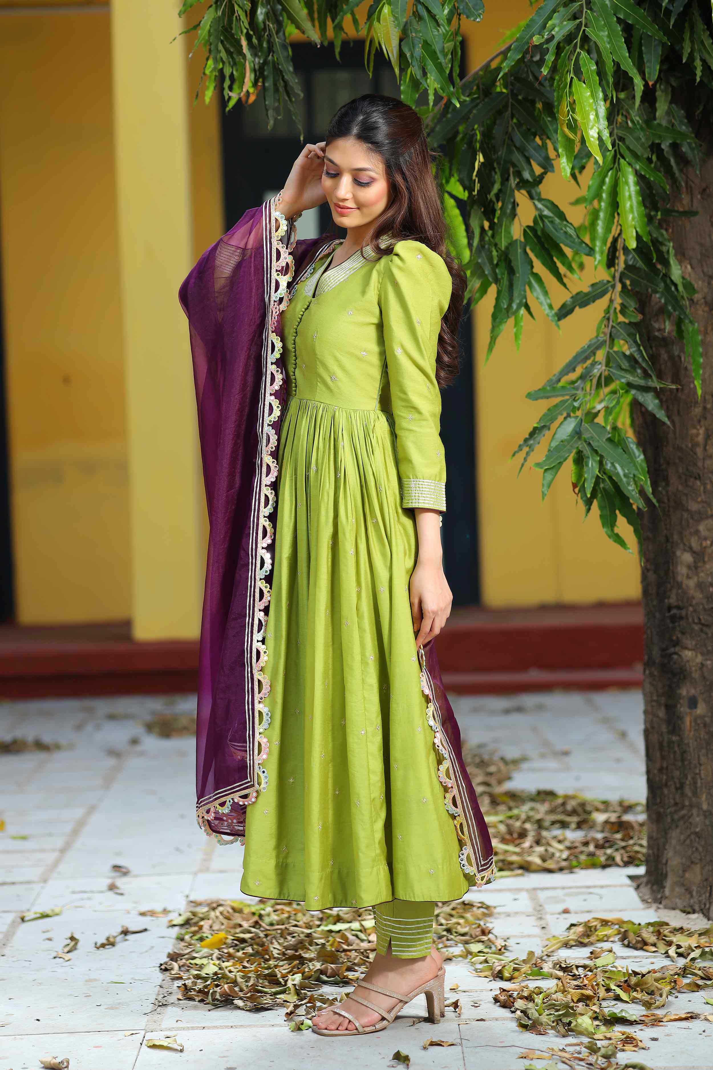 a woman in green Anarkali suit set with pent