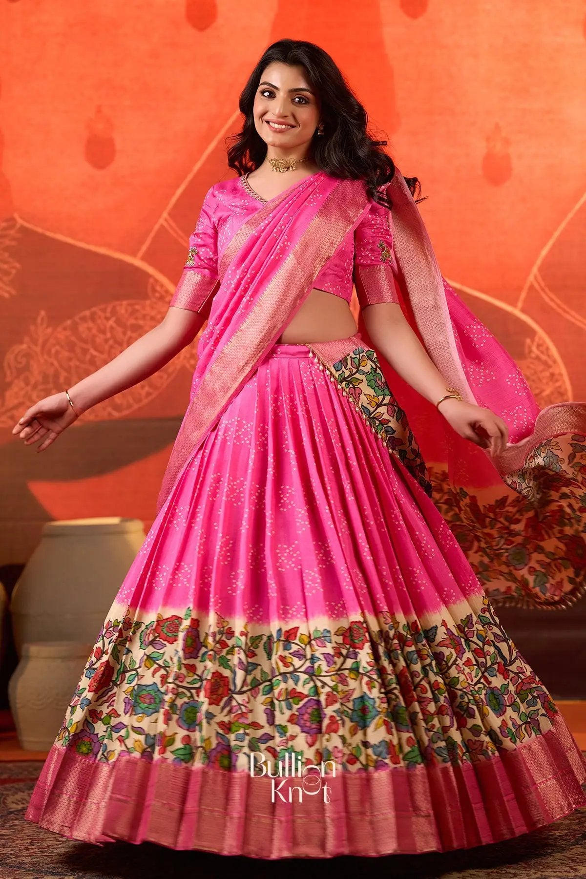 Twirl shot of Gokulika Lehenga Set In Pink at bullionknot showing full flare and colorful floral hem, ideal for traditional and ceremonial clothing.