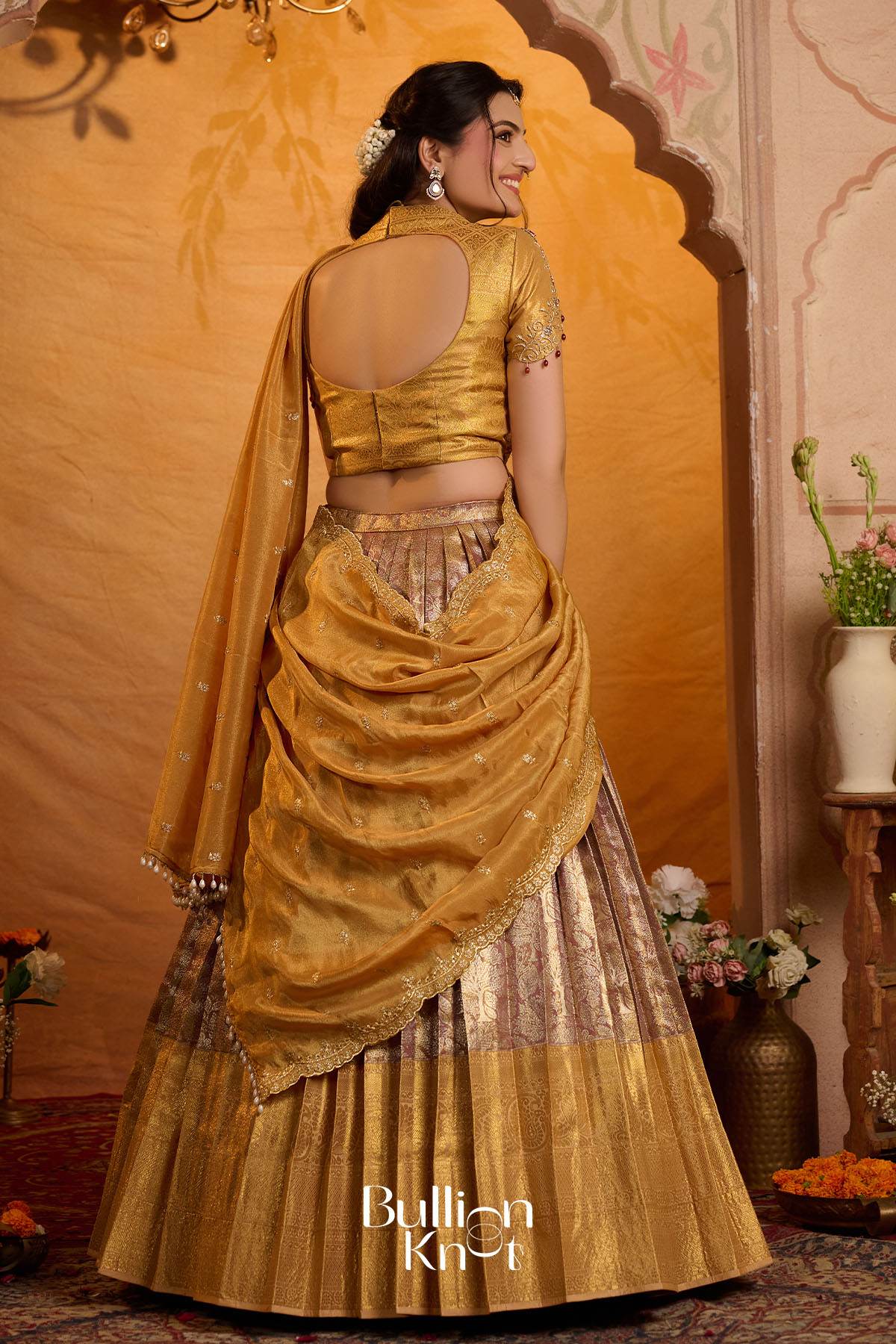 Golden lehenga with draped dupatta and traditional embroidery