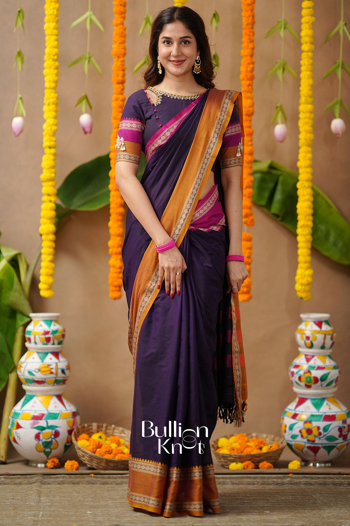 Woman in a purple saree with orange border front view